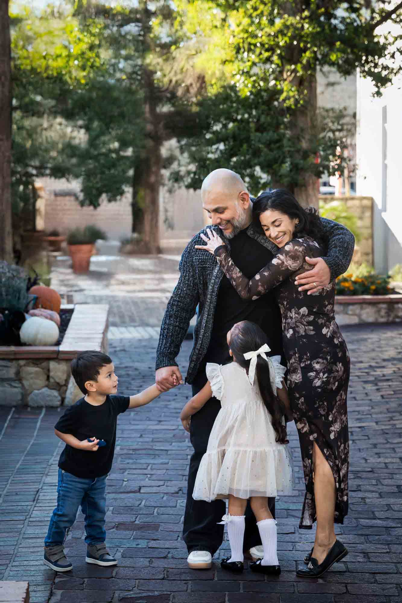 Little boy and girl enthusiastically hugging parents during a La Villita family portrait session