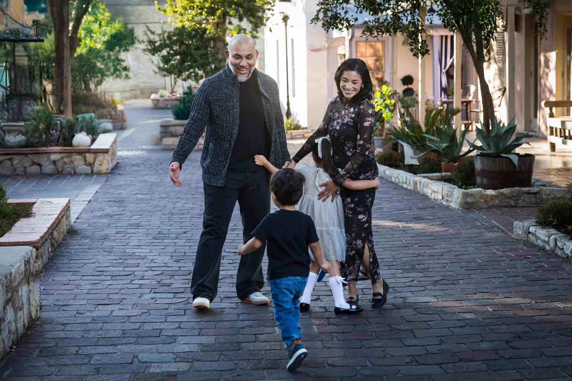 Little boy and girl enthusiastically hugging parents during a La Villita family portrait session