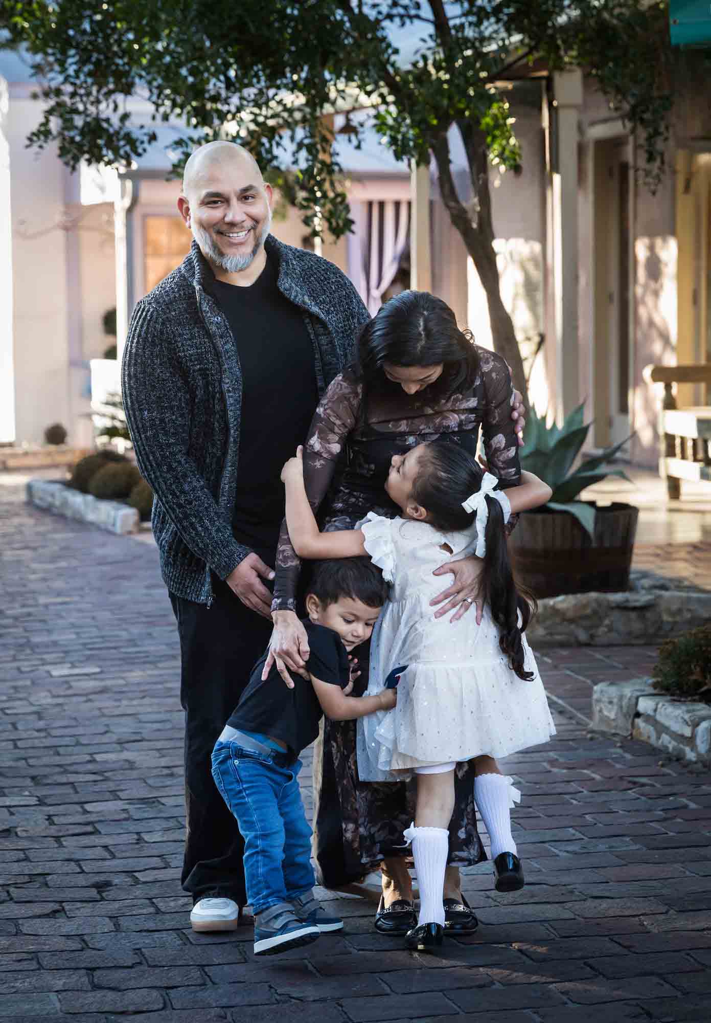 Little boy and girl enthusiastically hugging parents during a La Villita family portrait session