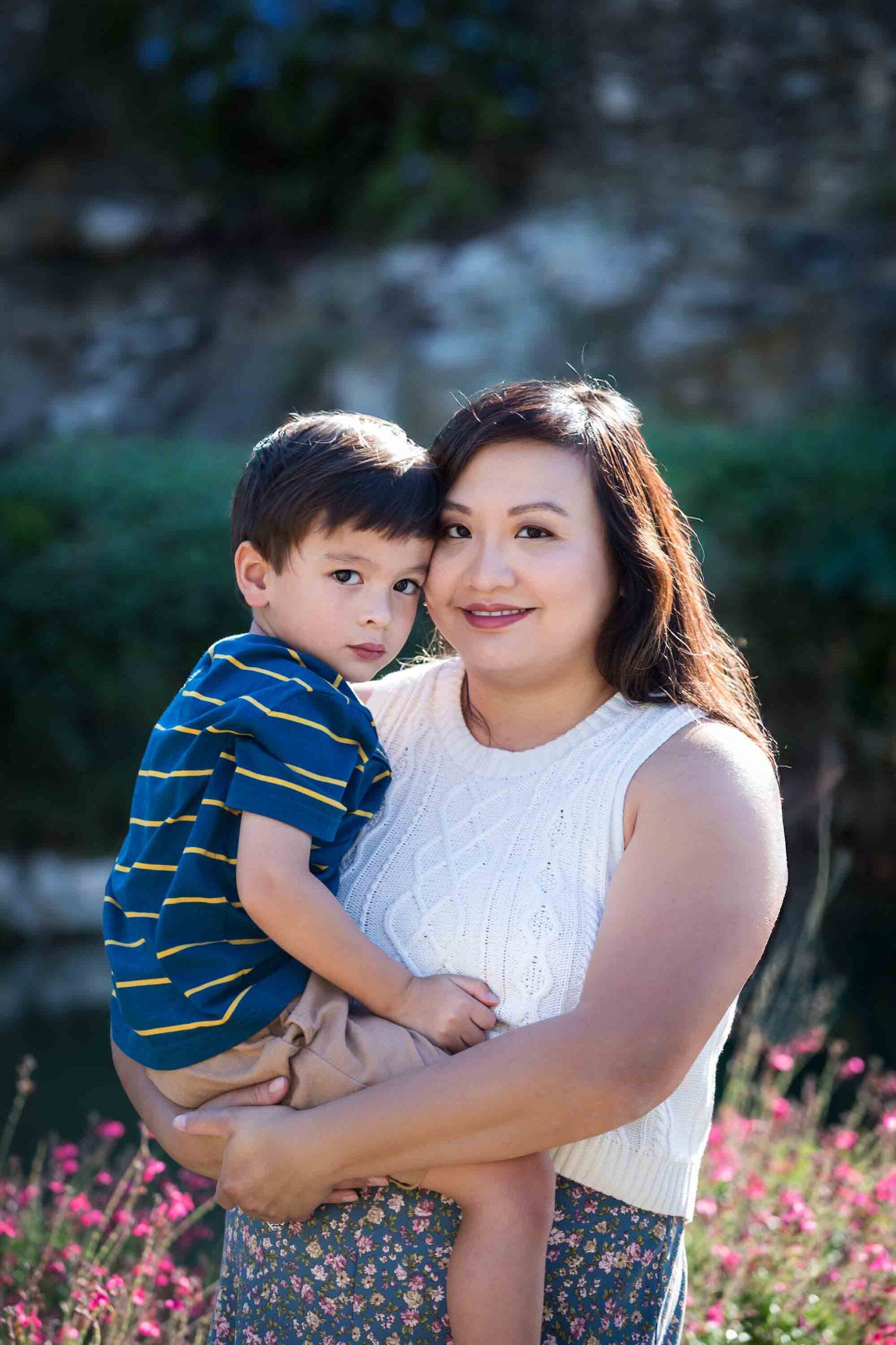 Mother holding little boy with brown hair wearing striped shirt for an article on photo tips for families with young children