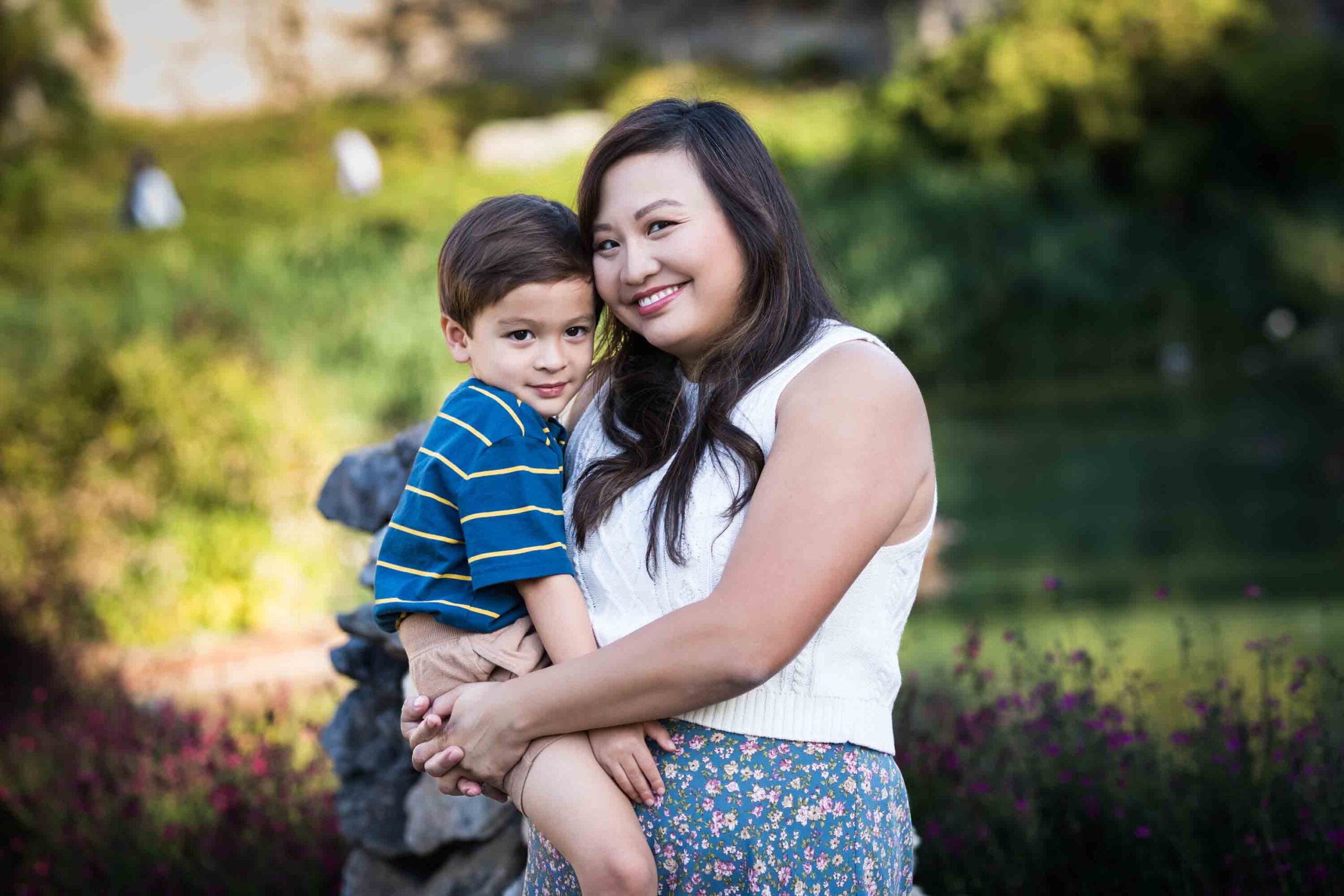 Mother holding little boy with brown hair wearing striped shirt for an article on photo tips for families with young children