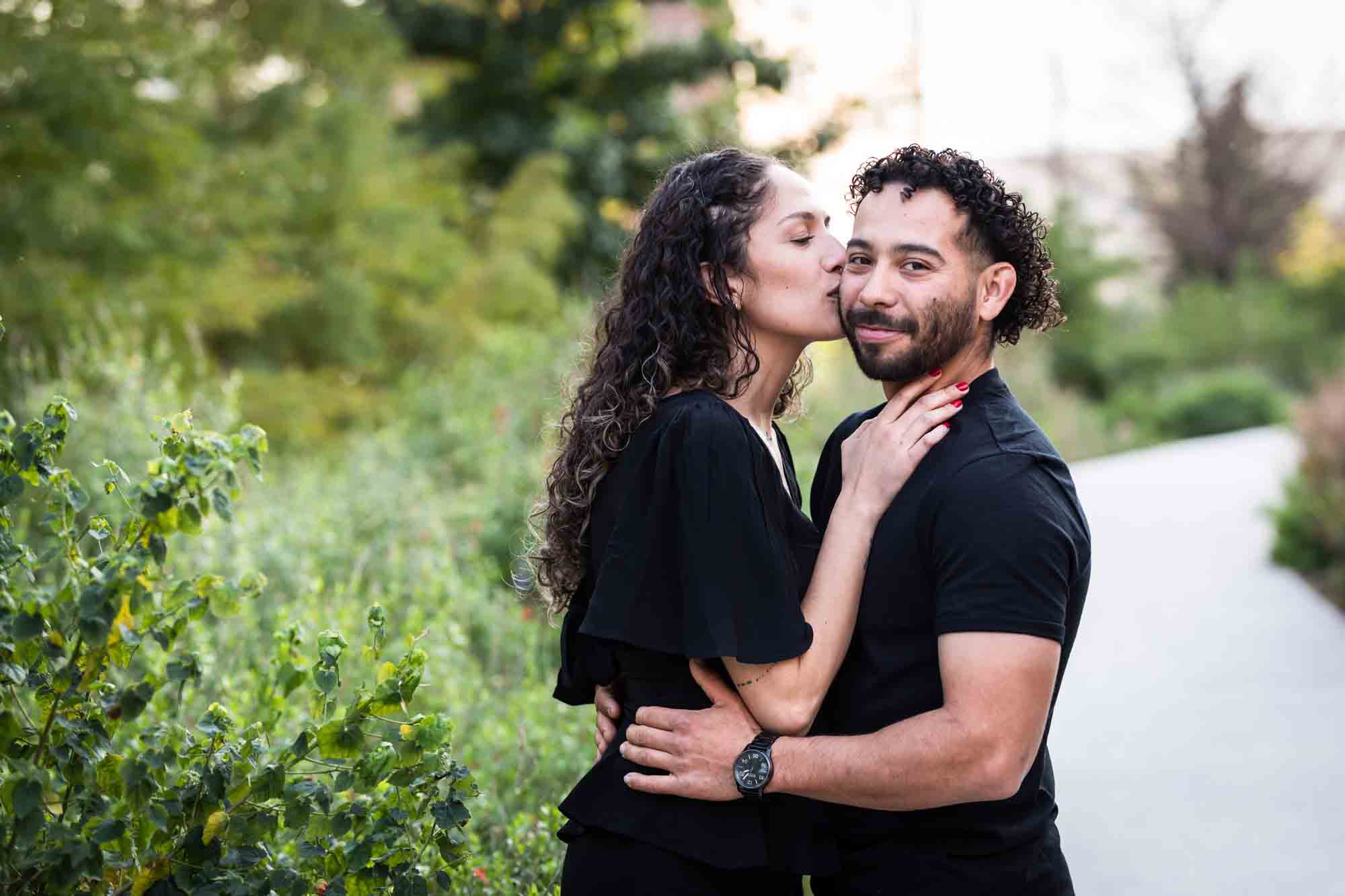 Couple wearing black t-shirts in front of green bushes during a San Pedro Creek Park family portrait session