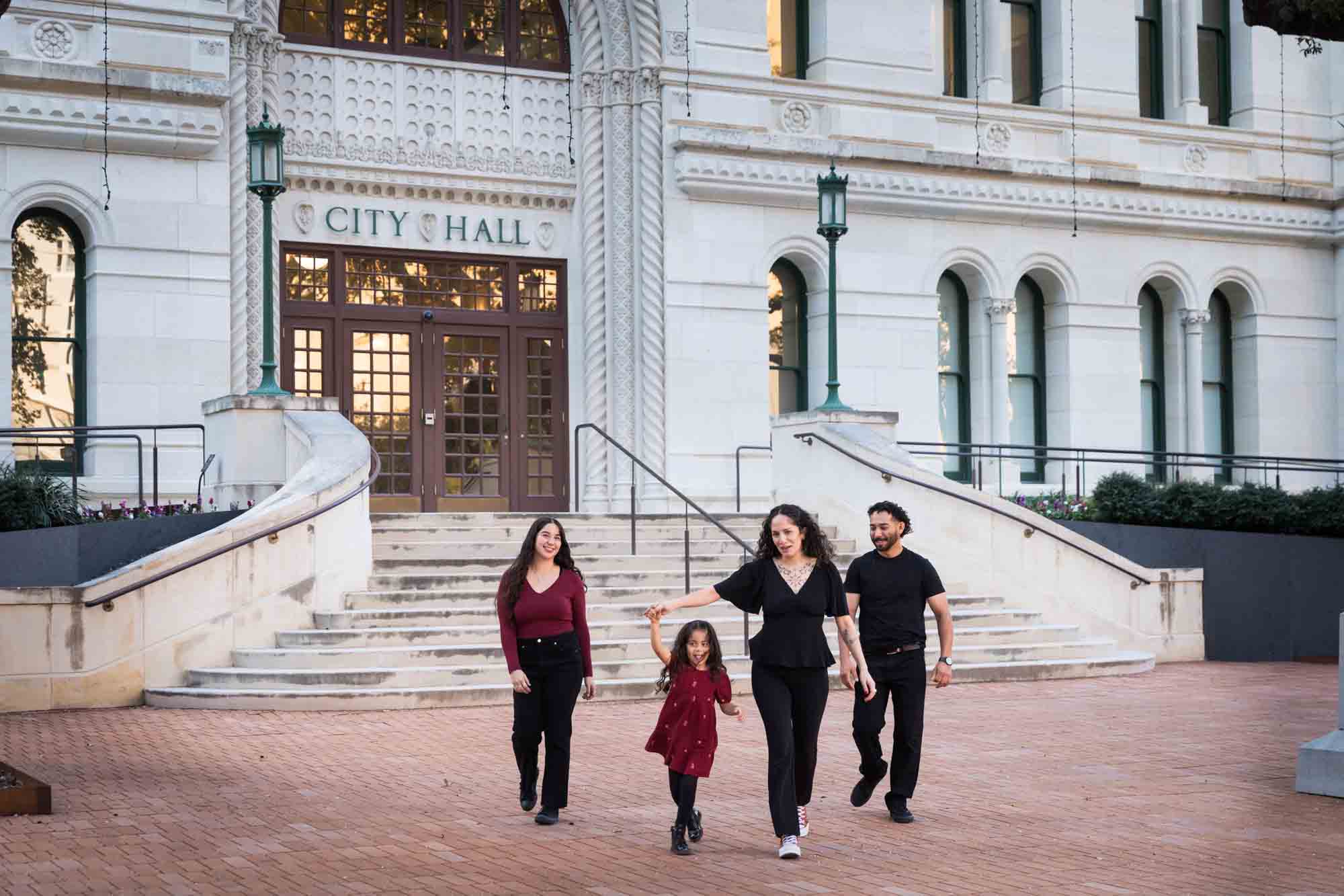 Parents and two daughters walking in front of San Antonio City Hall entrance