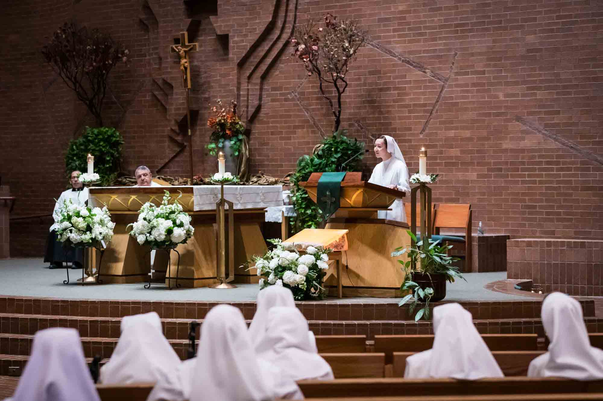 Nun speaking at podium in front of guests at a St. Mark the Evangelist Catholic Church wedding