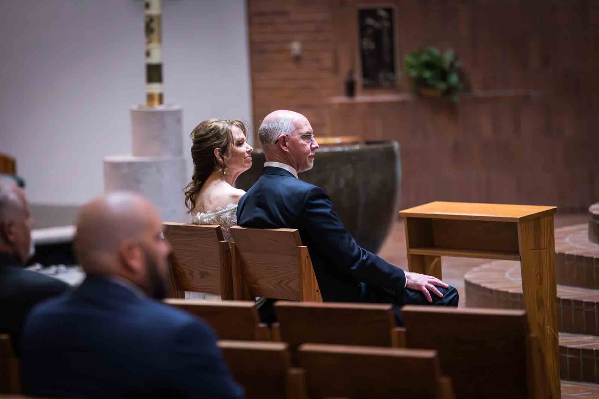 Bride and groom watching musical performance with guests at a St. Mark the Evangelist Catholic Church wedding