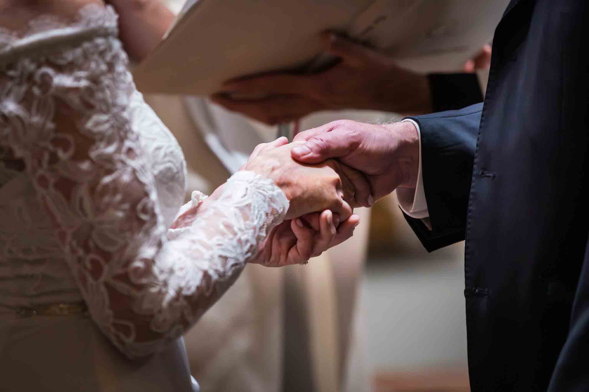 Close up of bride and groom holding hands at a St. Mark the Evangelist Catholic Church wedding