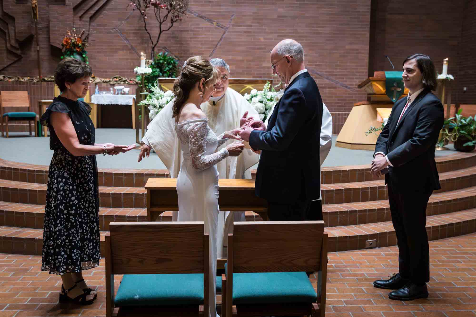 Bride and groom exchanging rings at a St. Mark the Evangelist Catholic Church wedding