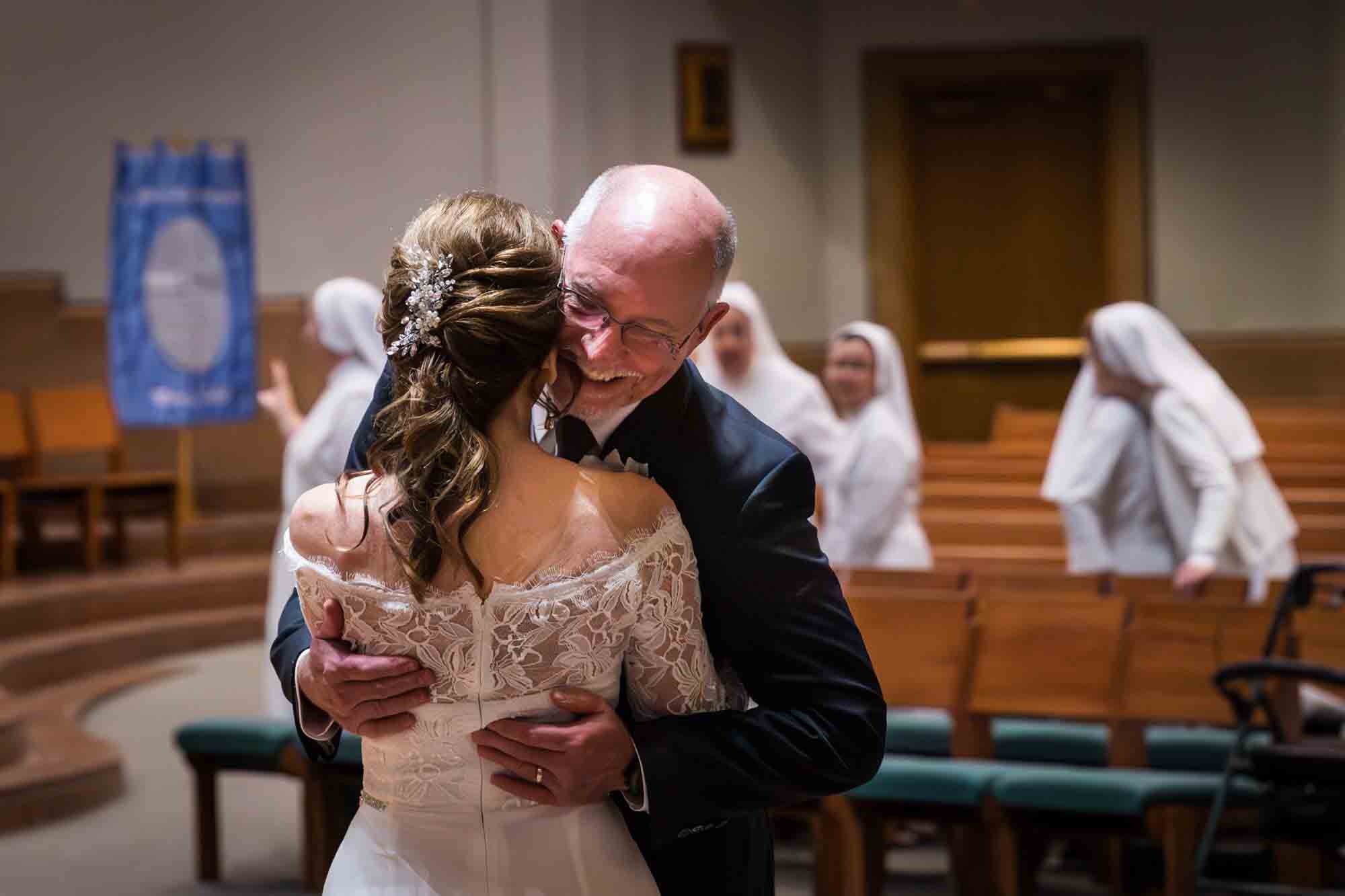 Bride ad groom hugging in front of guests at a St. Mark the Evangelist Catholic Church wedding