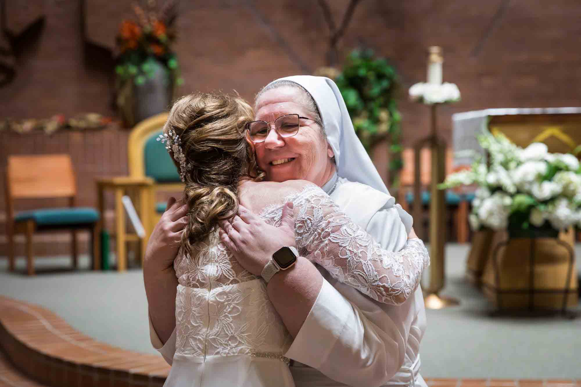 Nun hugging bride at a St. Mark the Evangelist Catholic Church wedding