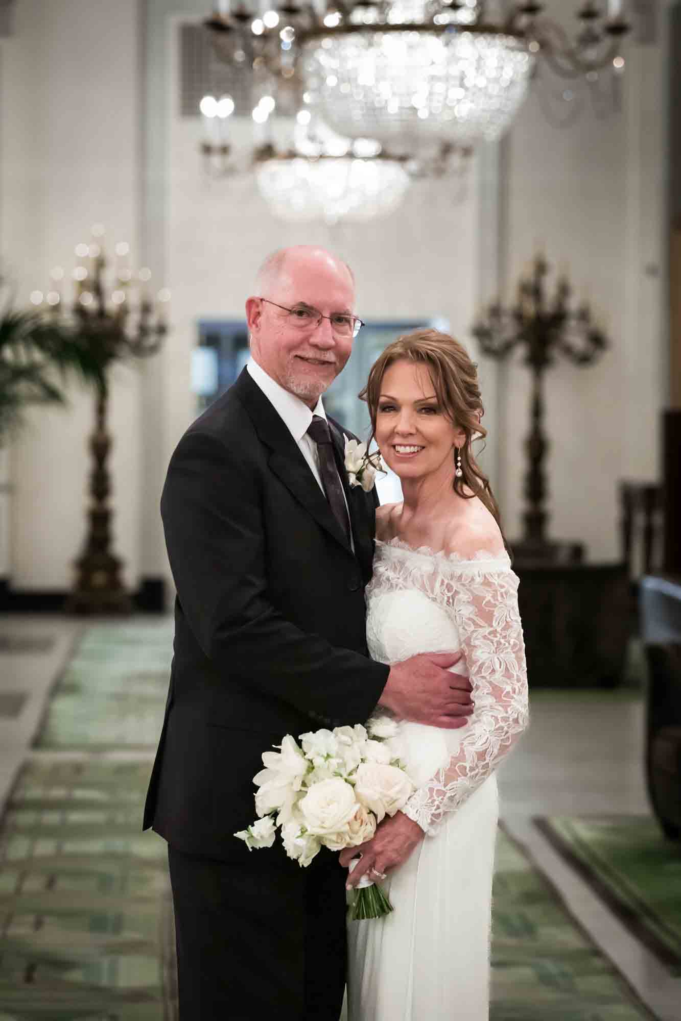 Bride and groom hugging in Peacock Alley at St. Anthony Hotel