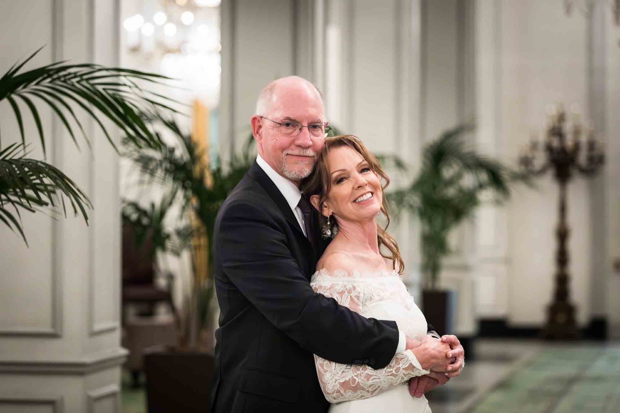 Bride and groom hugging in Peacock Alley at St. Anthony Hotel