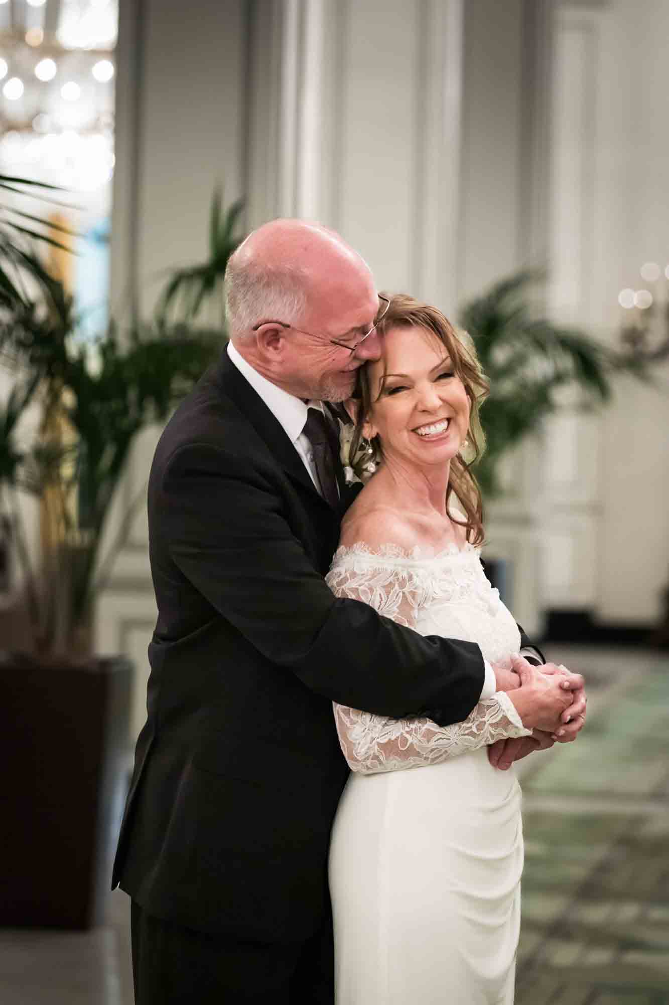 Bride and groom hugging in Peacock Alley at St. Anthony Hotel