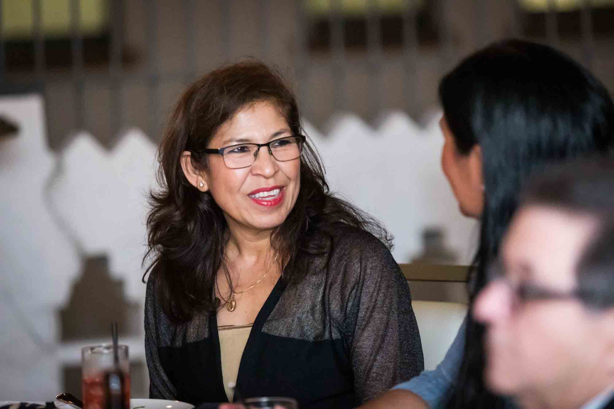 Woman wearing glasses and black dress at the Sky Terrace during a St. Anthony Hotel reception