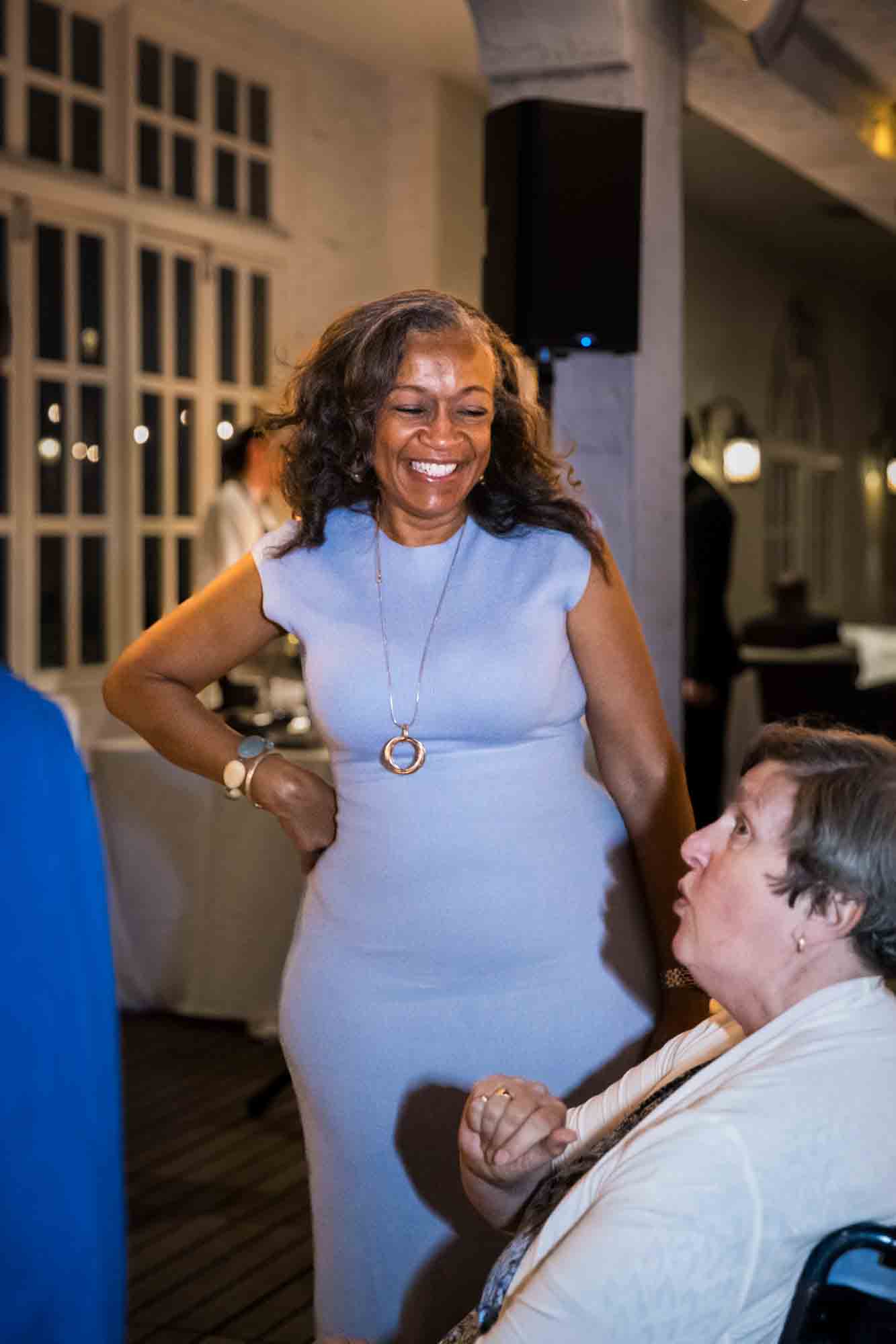 African American woman standing with older woman during St. Anthony Hotel wedding reception