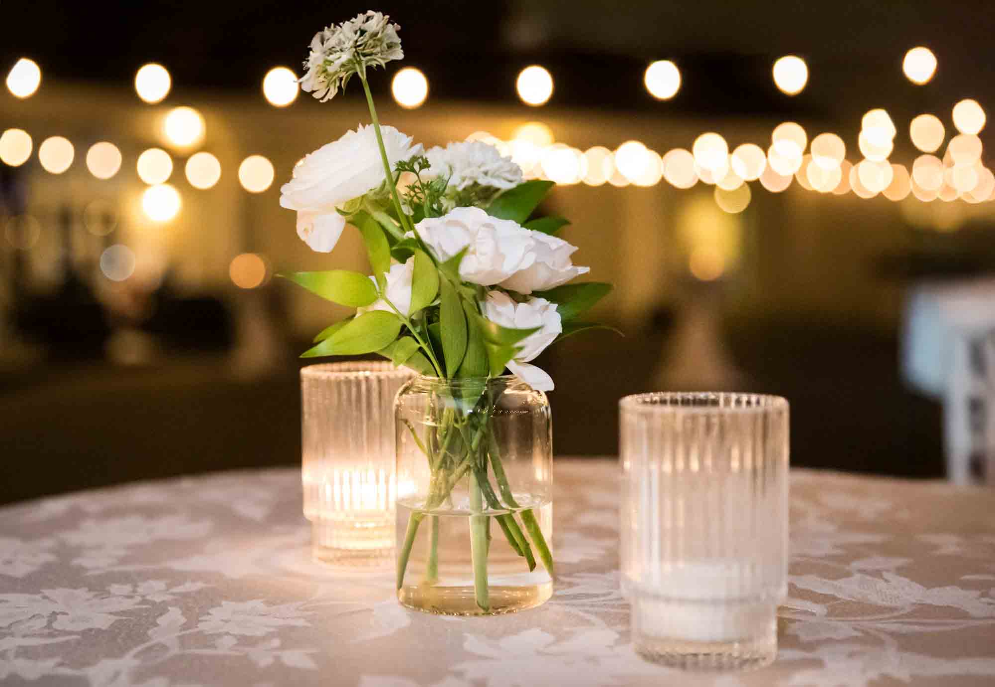 Table set with candles and small centerpiece of white flowers during St. Anthony Hotel wedding reception