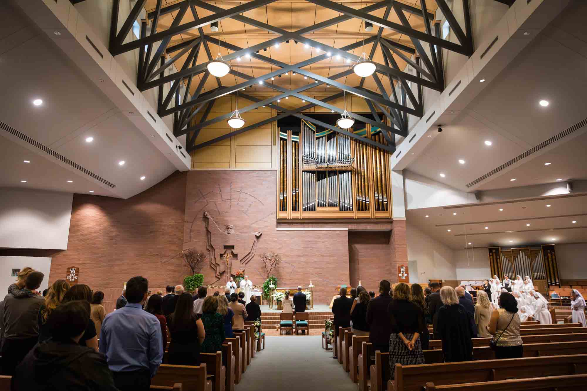 Wide shot of guests watching speakers at a St. Mark the Evangelist Catholic Church wedding