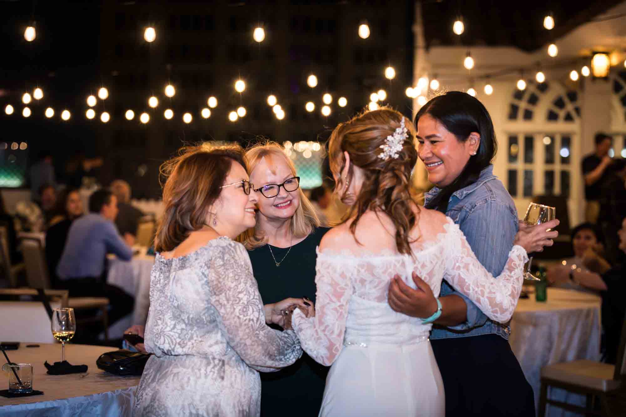 Guests smiling and talking with one another on the Sky Terrace during a wedding reception