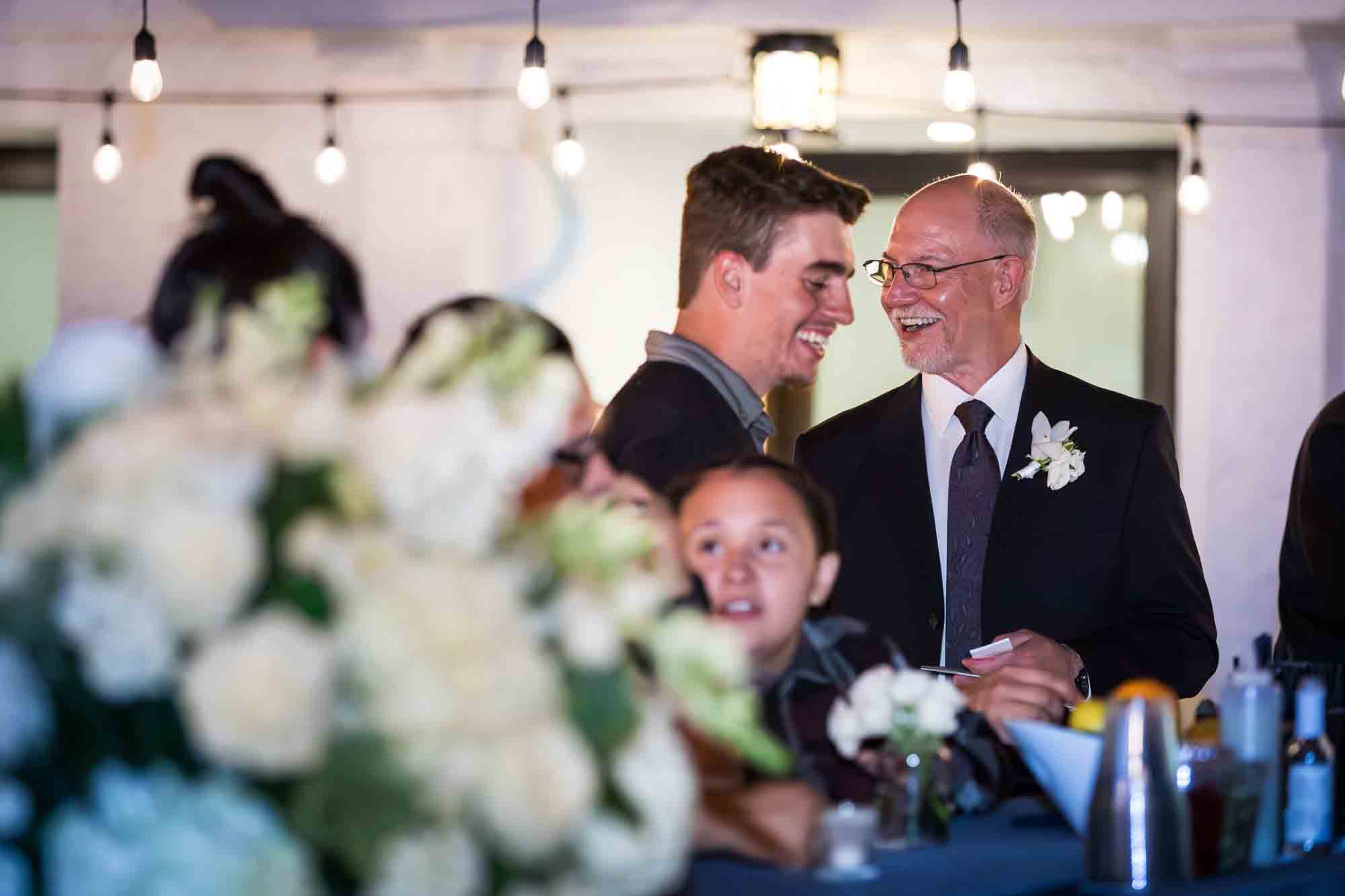 Guests smiling and talking with one another on the Sky Terrace during a wedding reception