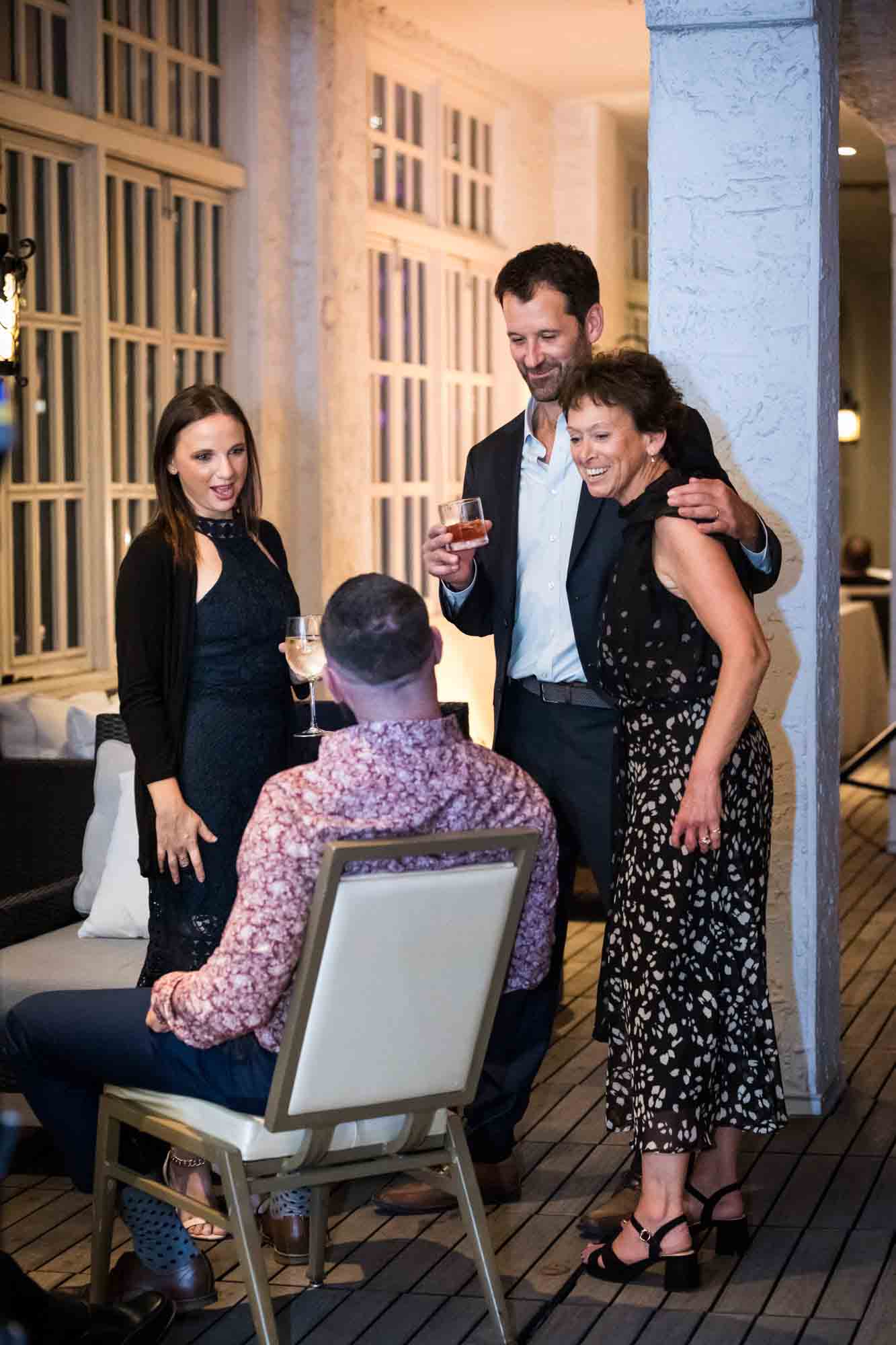 Guests smiling and talking with one another on the Sky Terrace during a wedding reception