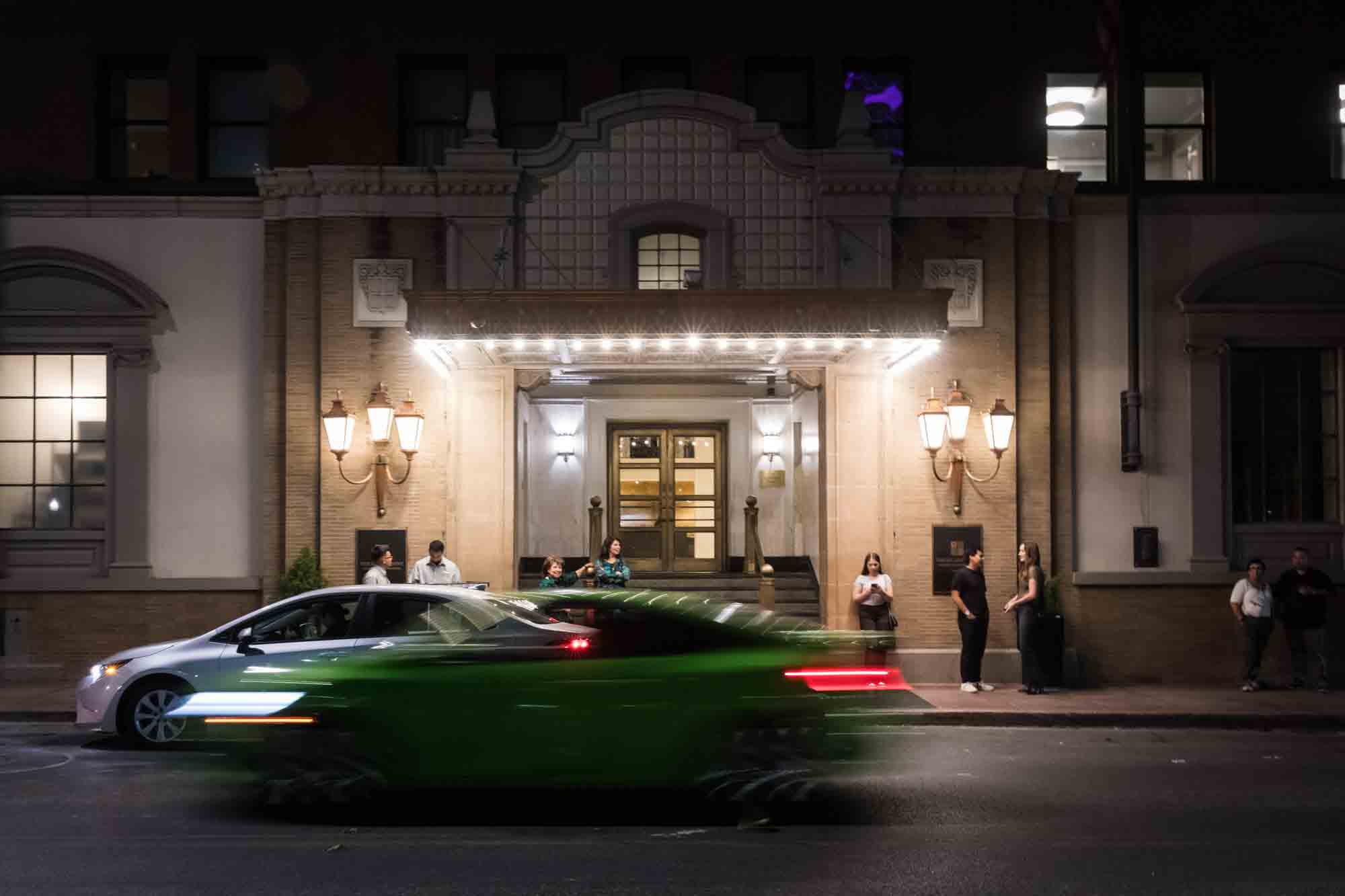 Blur of traffic going past the St. Anthony Hotel at night in San Antonio