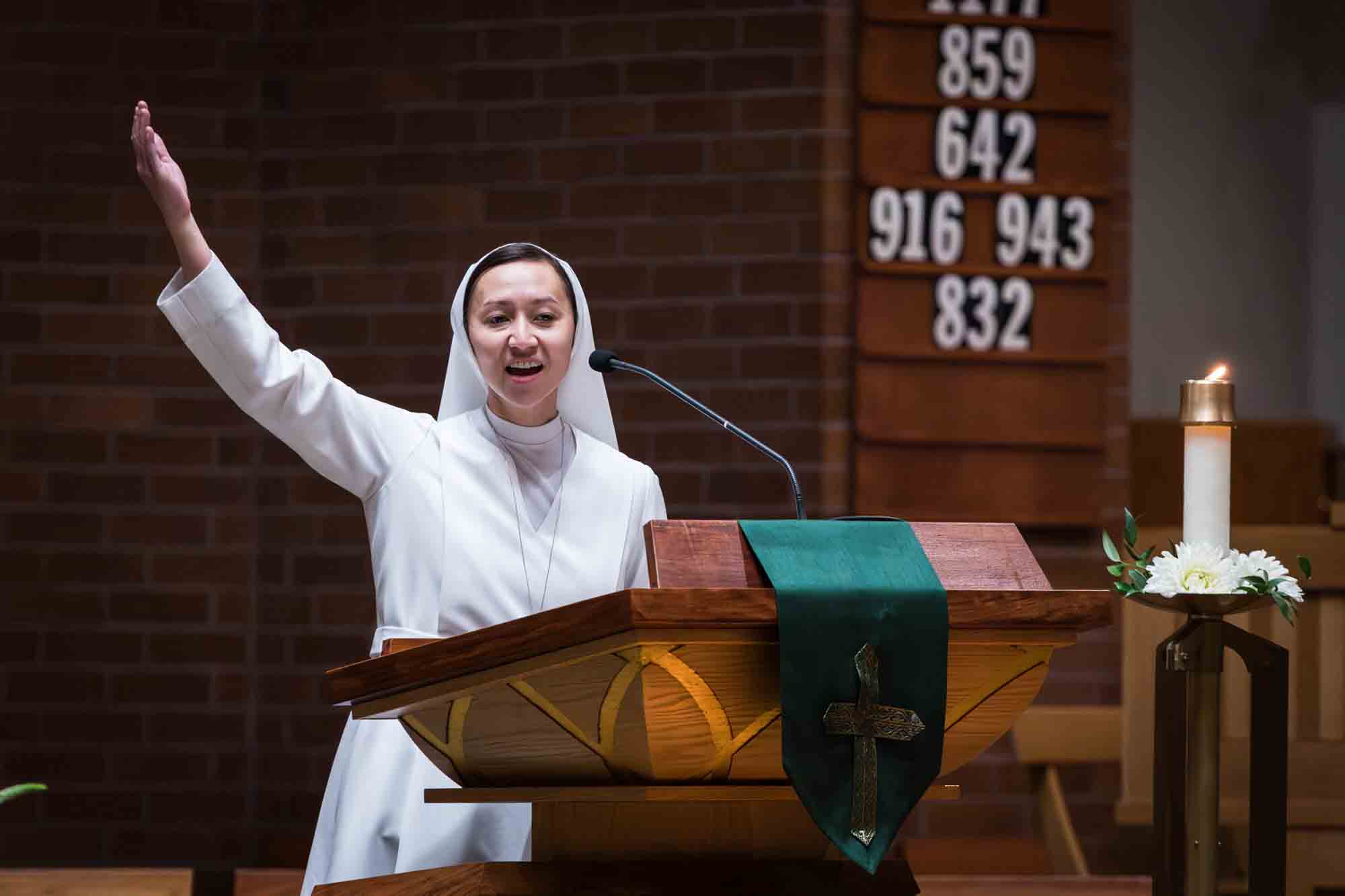 Nun speaking at podium with hand outstretched at a St. Mark the Evangelist Catholic Church wedding