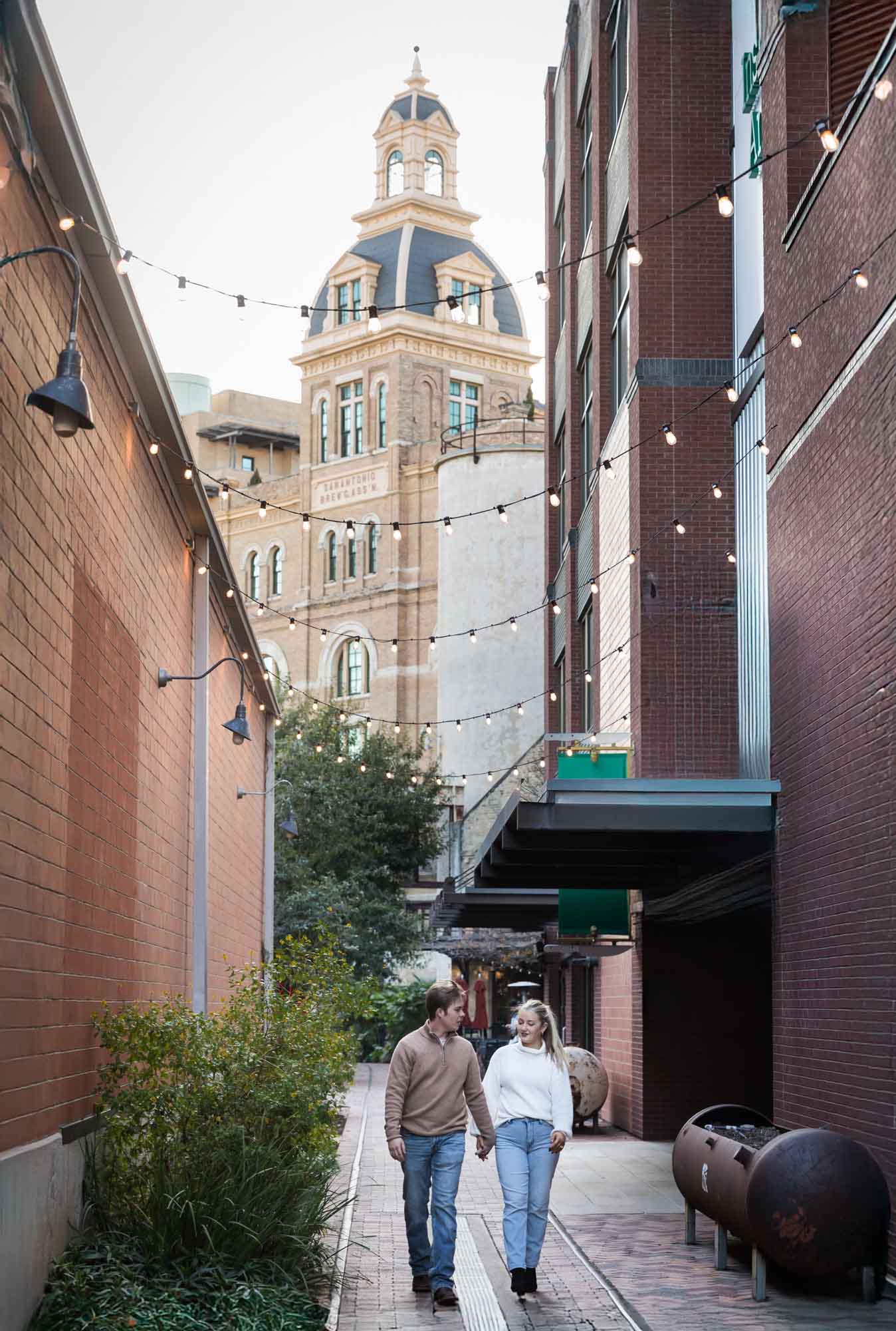 Couple walking down alleyway at the historic Pearl for an article on the importance of timing for a surprise proposal