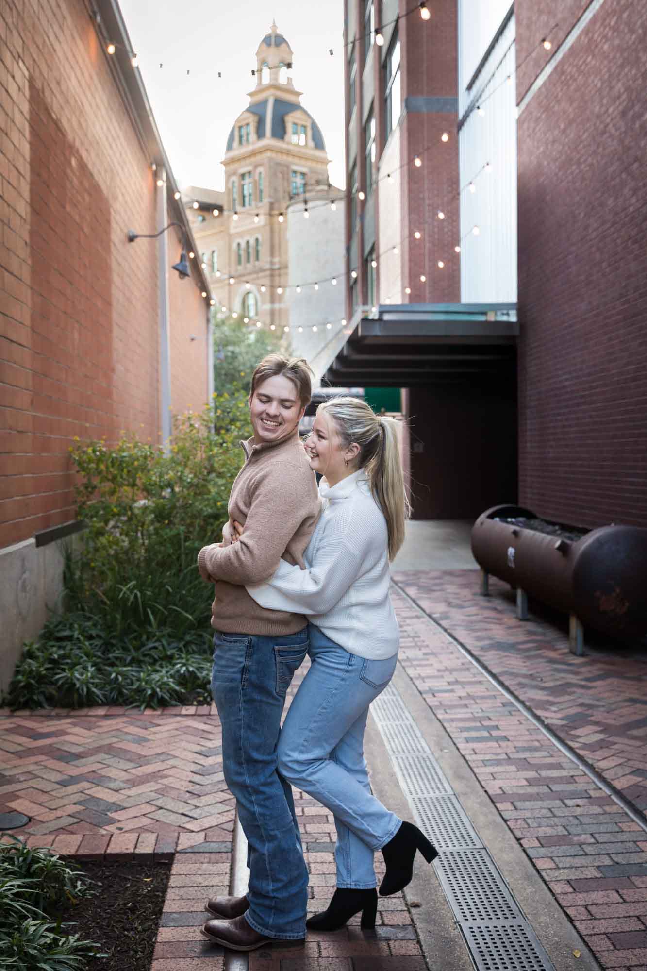 Couple hugging in alleyway at the historic Pearl for an article on the importance of timing for a surprise proposal