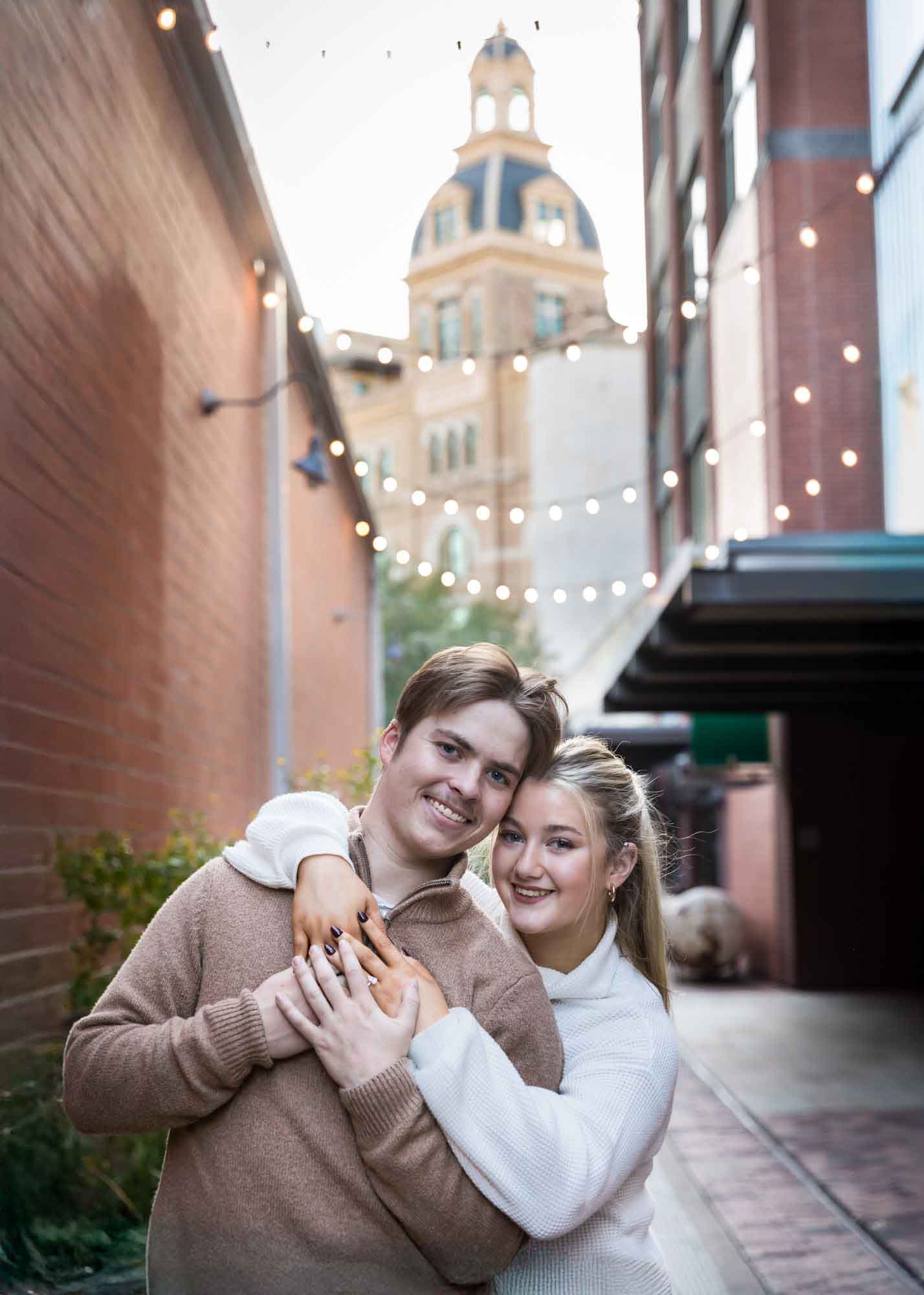 Couple hugging in alleyway at the historic Pearl for an article on the importance of timing for a surprise proposal