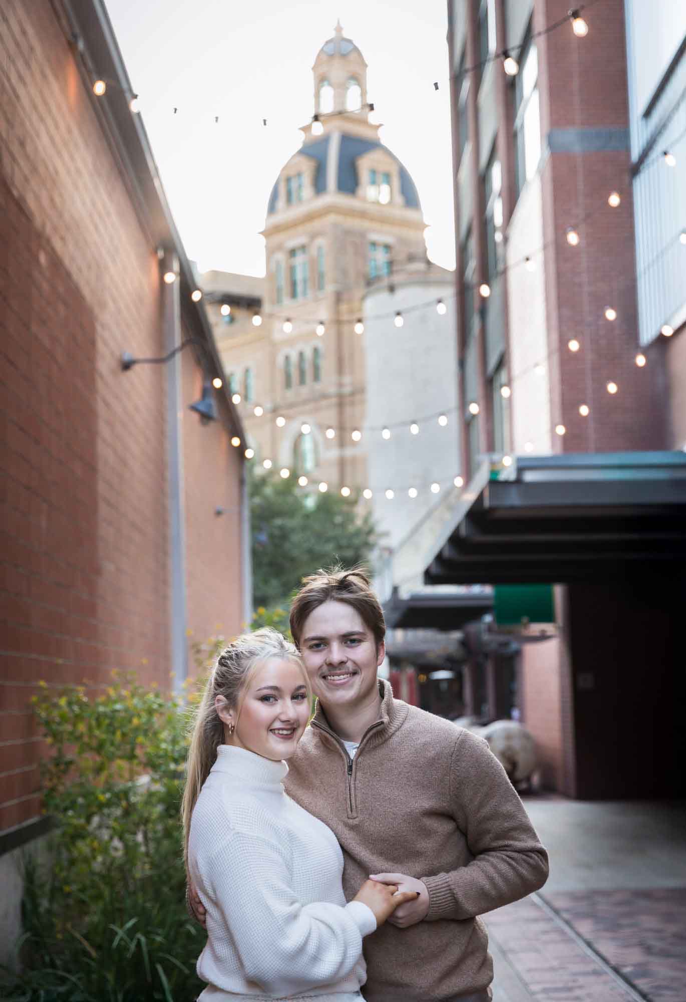 Couple hugging in alleyway at the historic Pearl for an article on the importance of timing for a surprise proposal