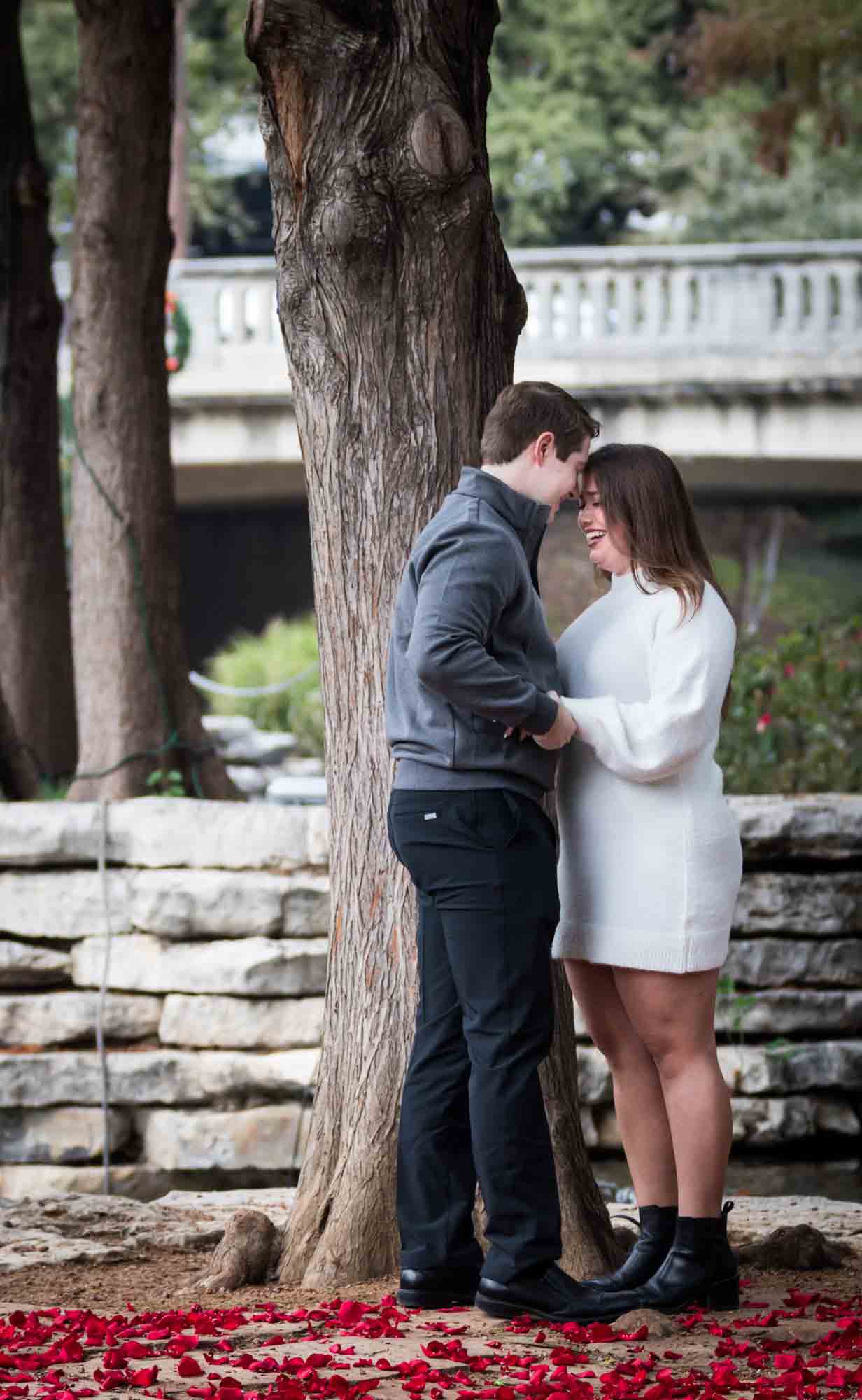 Couple hugging on little island during a surprise proposal at the Pearl