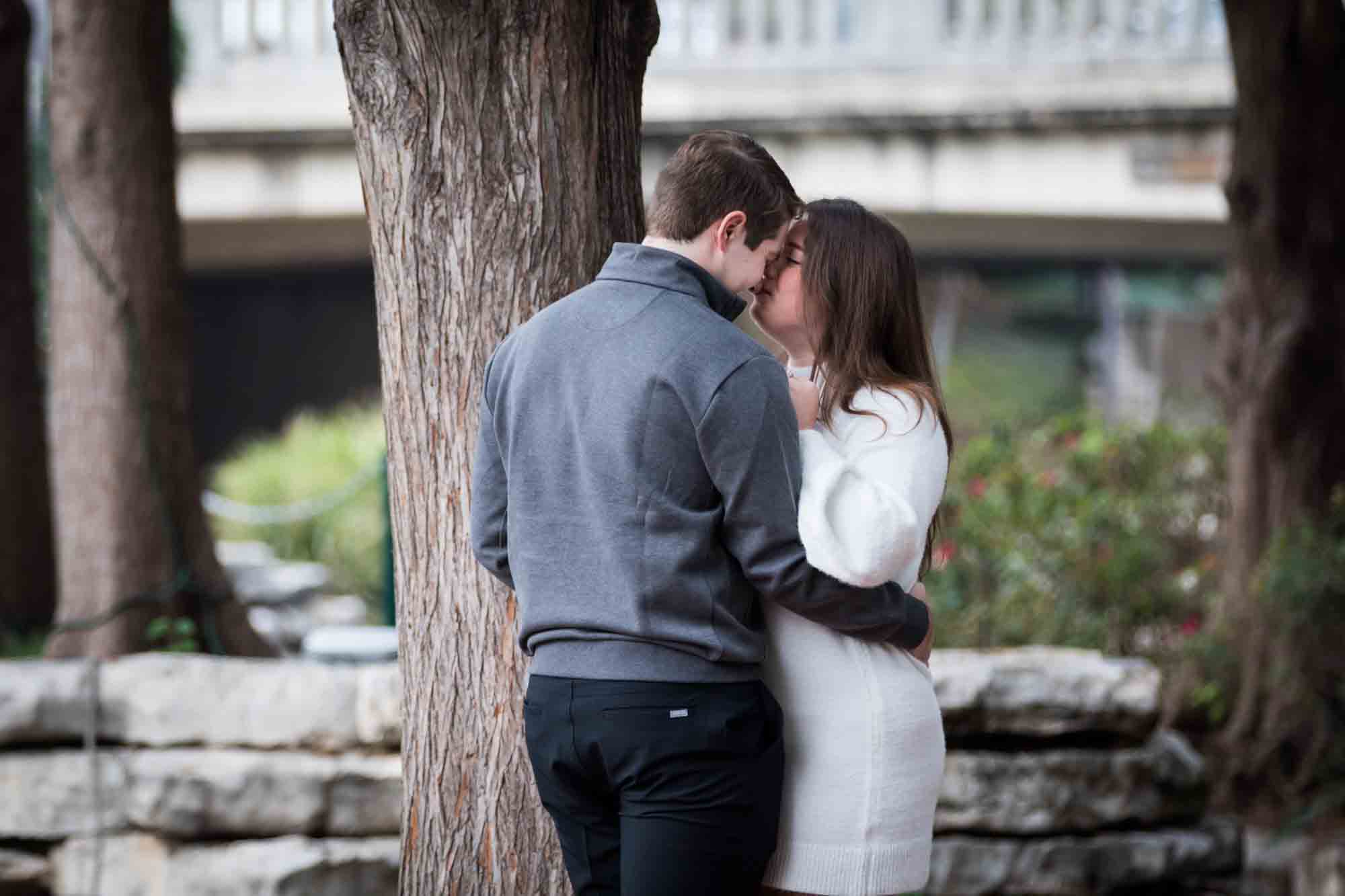 Couple hugging on little island during a surprise proposal at the Pearl