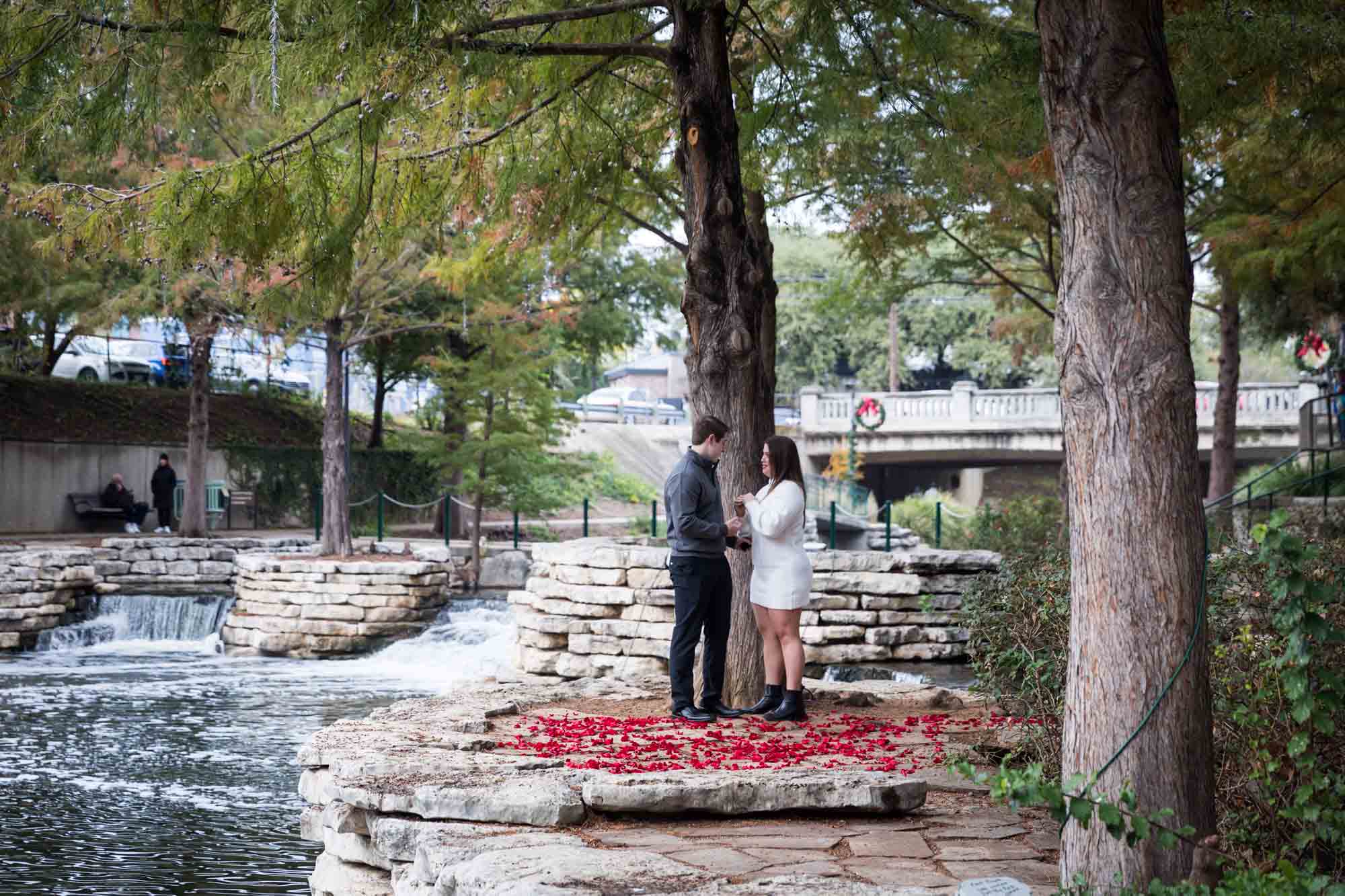 Couple hugging on little island during a surprise proposal at the Pearl