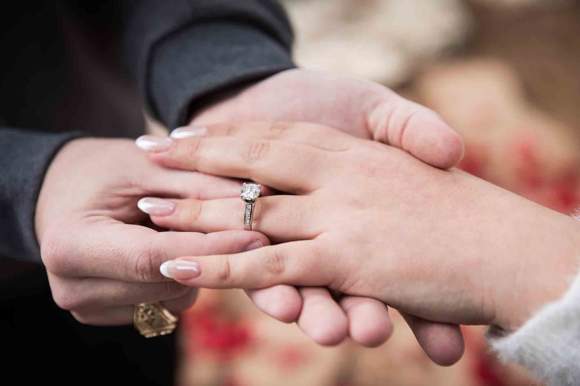 Close up of couple's hands showing engagement ring