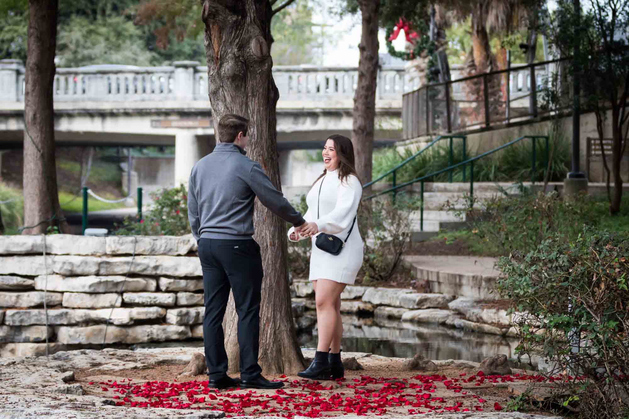 Couple hugging on little island during a surprise proposal at the Pearl