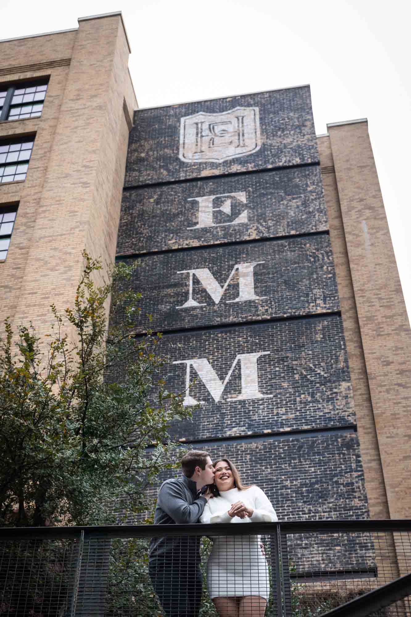 Couple kissing in front of Hotel Emma for an article on rain backup photo locations at the Pearl in San Antonio