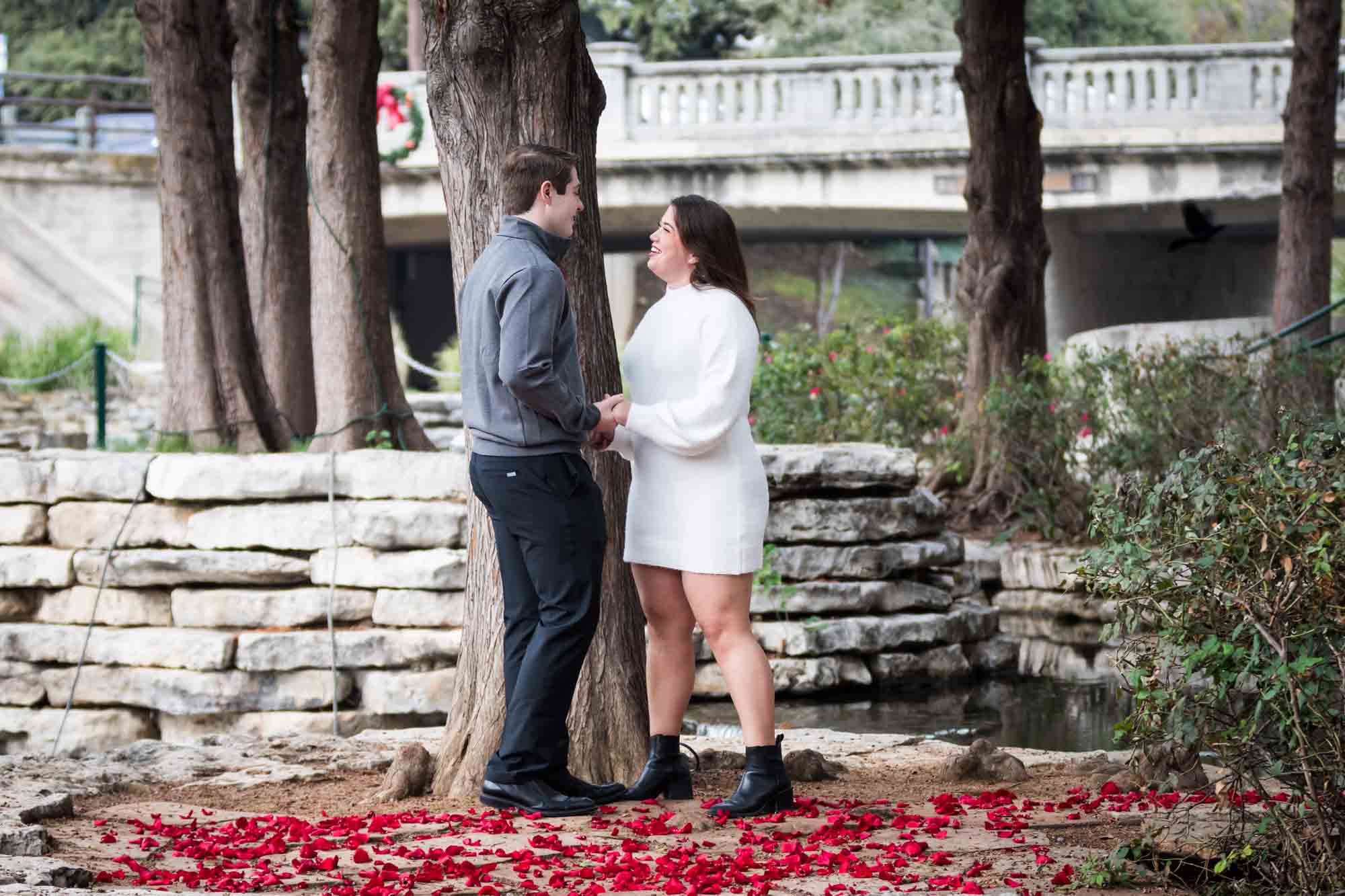 Couple hugging on little island during a surprise proposal at the Pearl