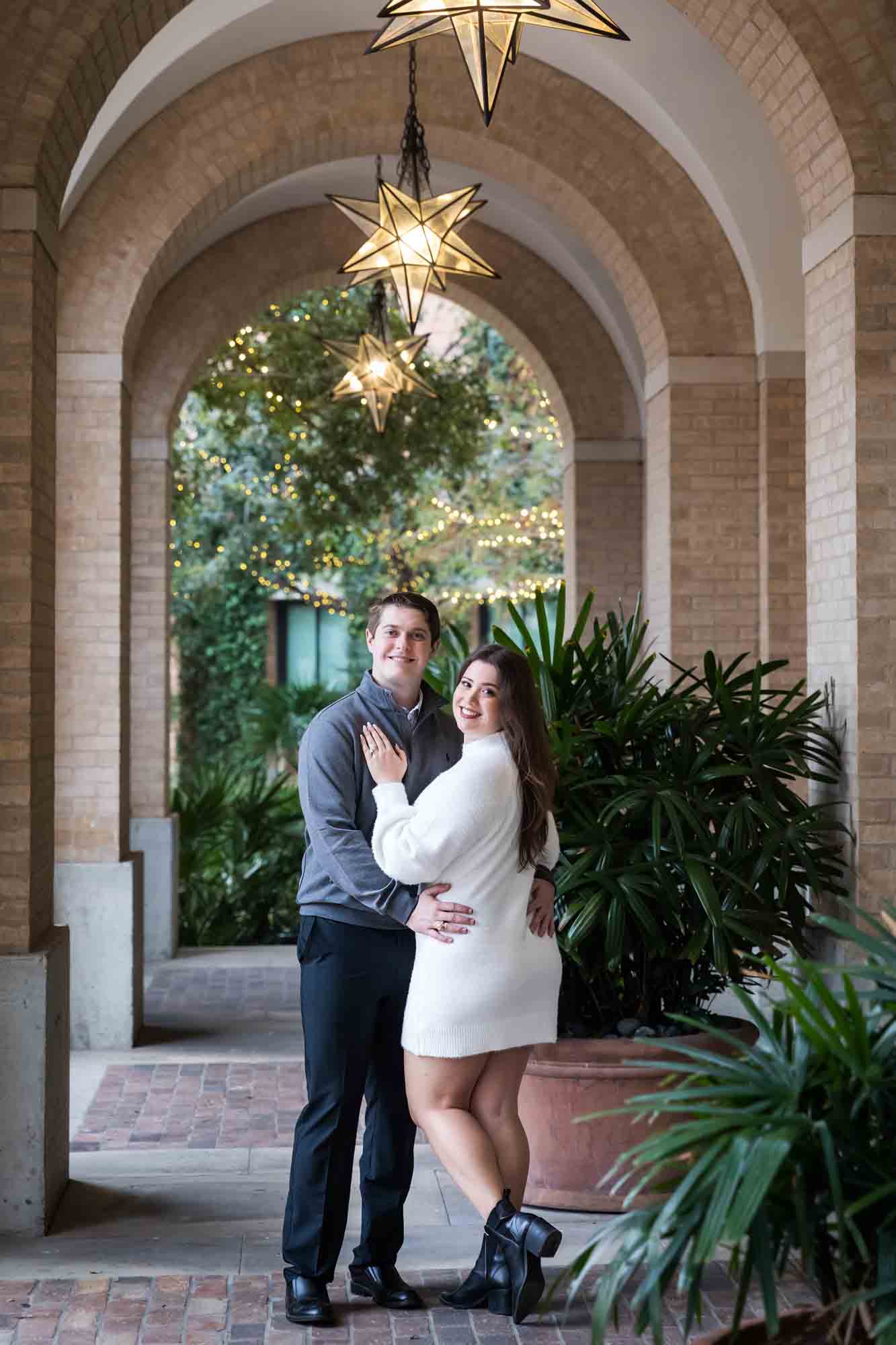 Couple hugging in Cellar vaulted entryway during an engagement photo shoot at the Pearl