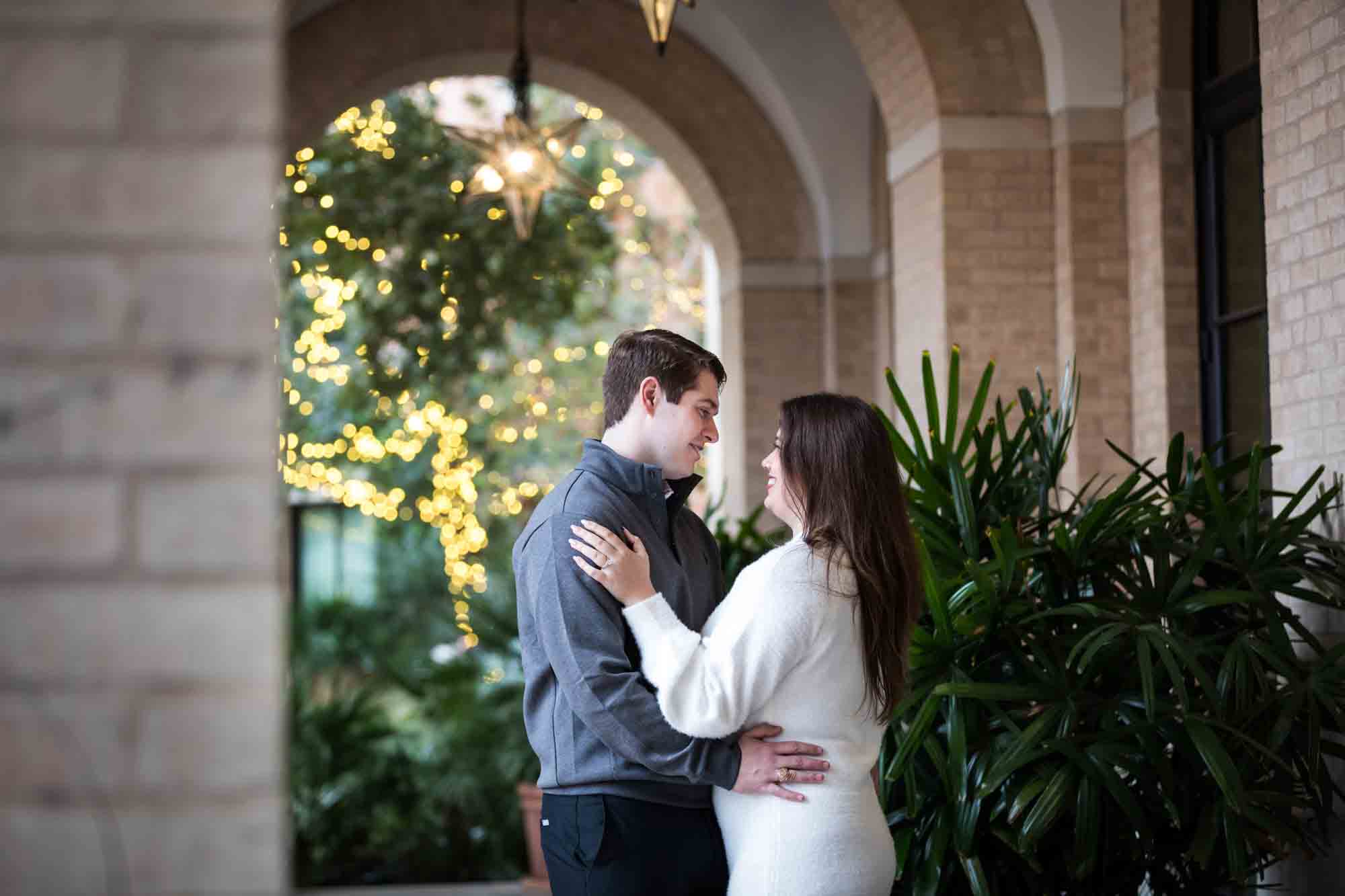 Couple hugging in Cellar vaulted entryway during an engagement photo shoot at the Pearl