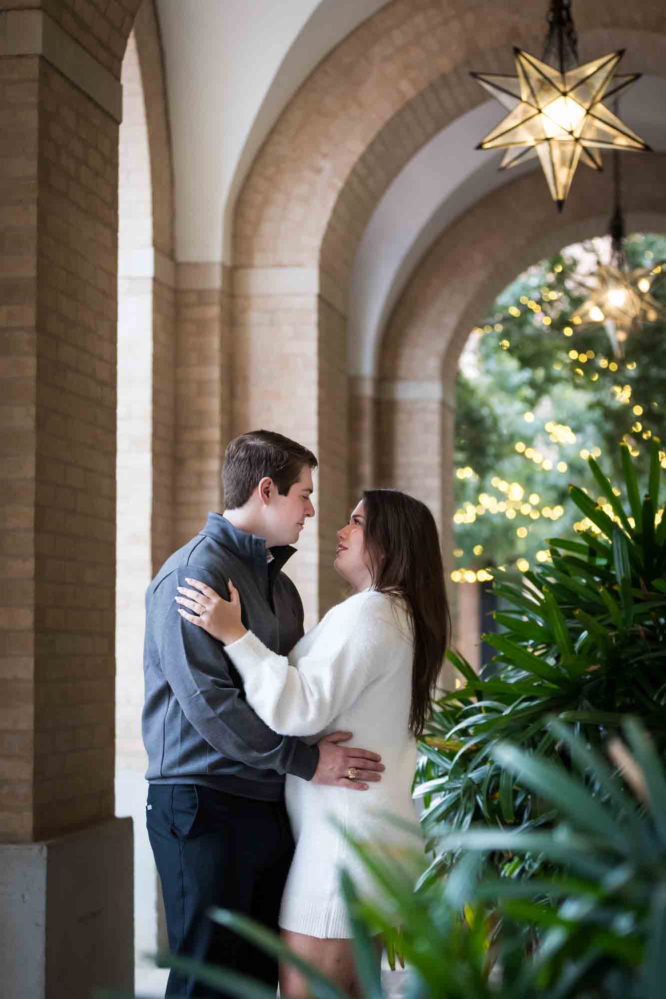 Couple hugging in Cellar vaulted entryway during an engagement photo shoot at the Pearl