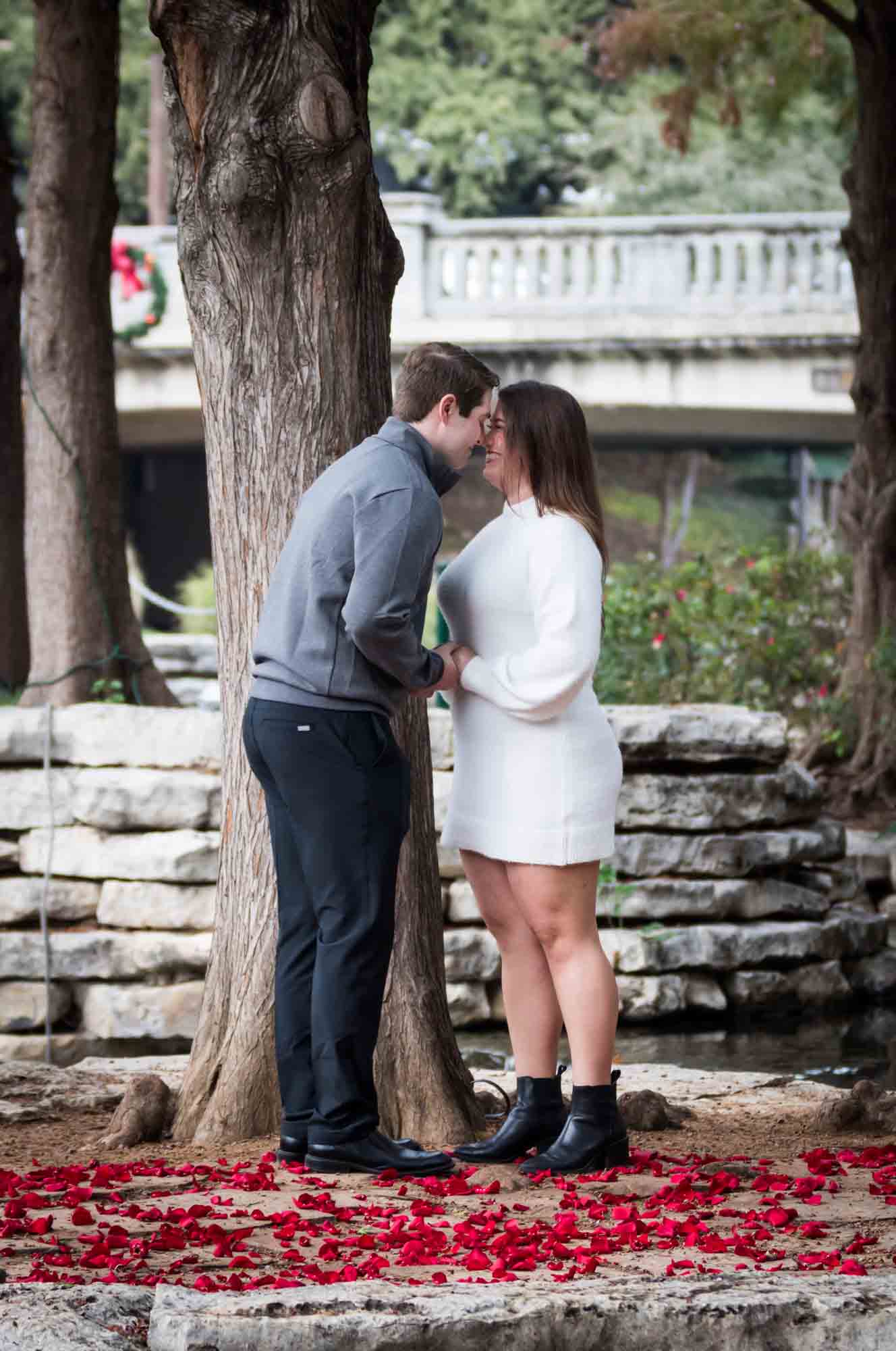 Couple hugging on little island during a surprise proposal at the Pearl