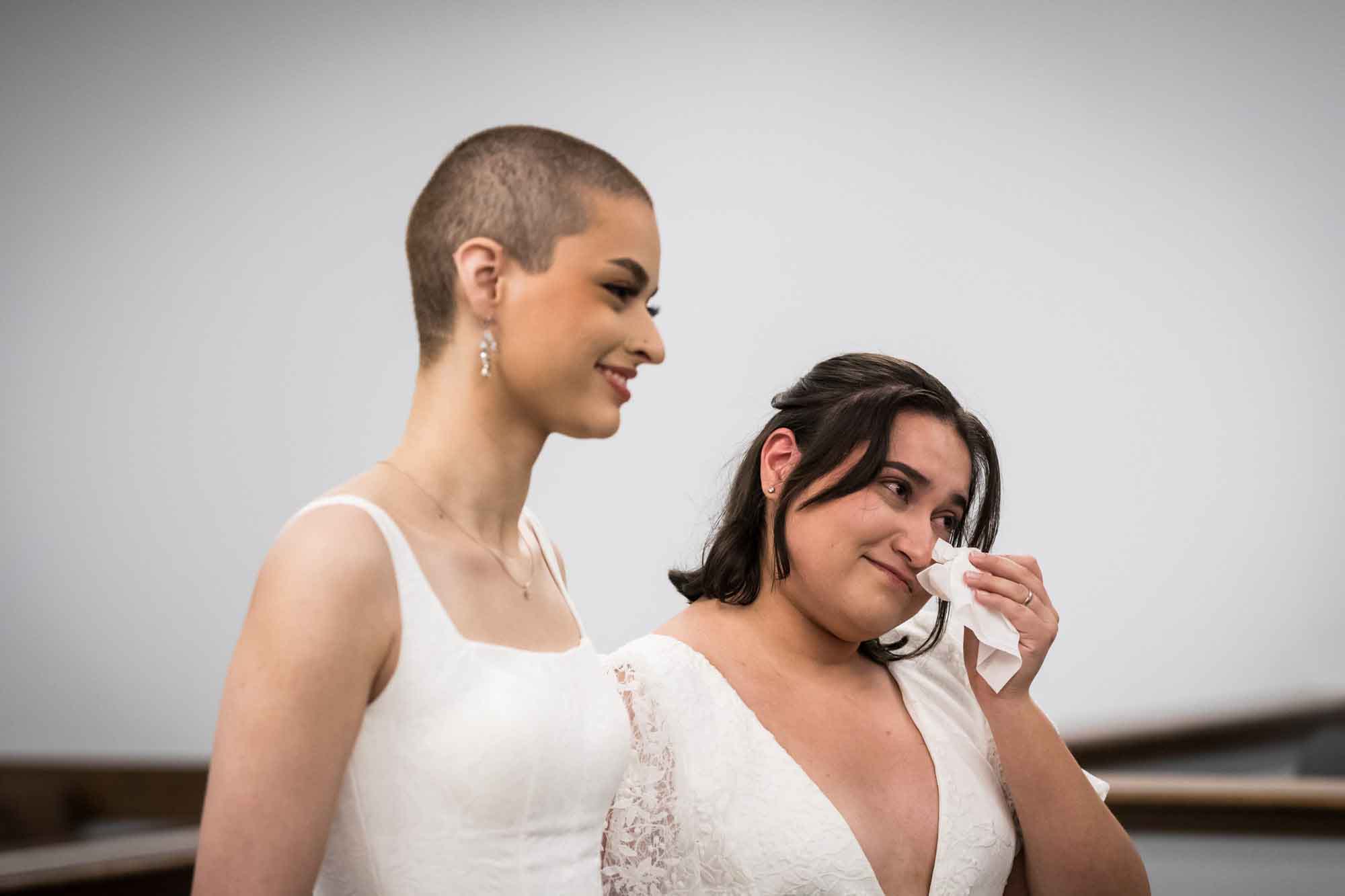 Two brides dressed in white during wedding ceremony at Bexar County Courthouse Precinct 3