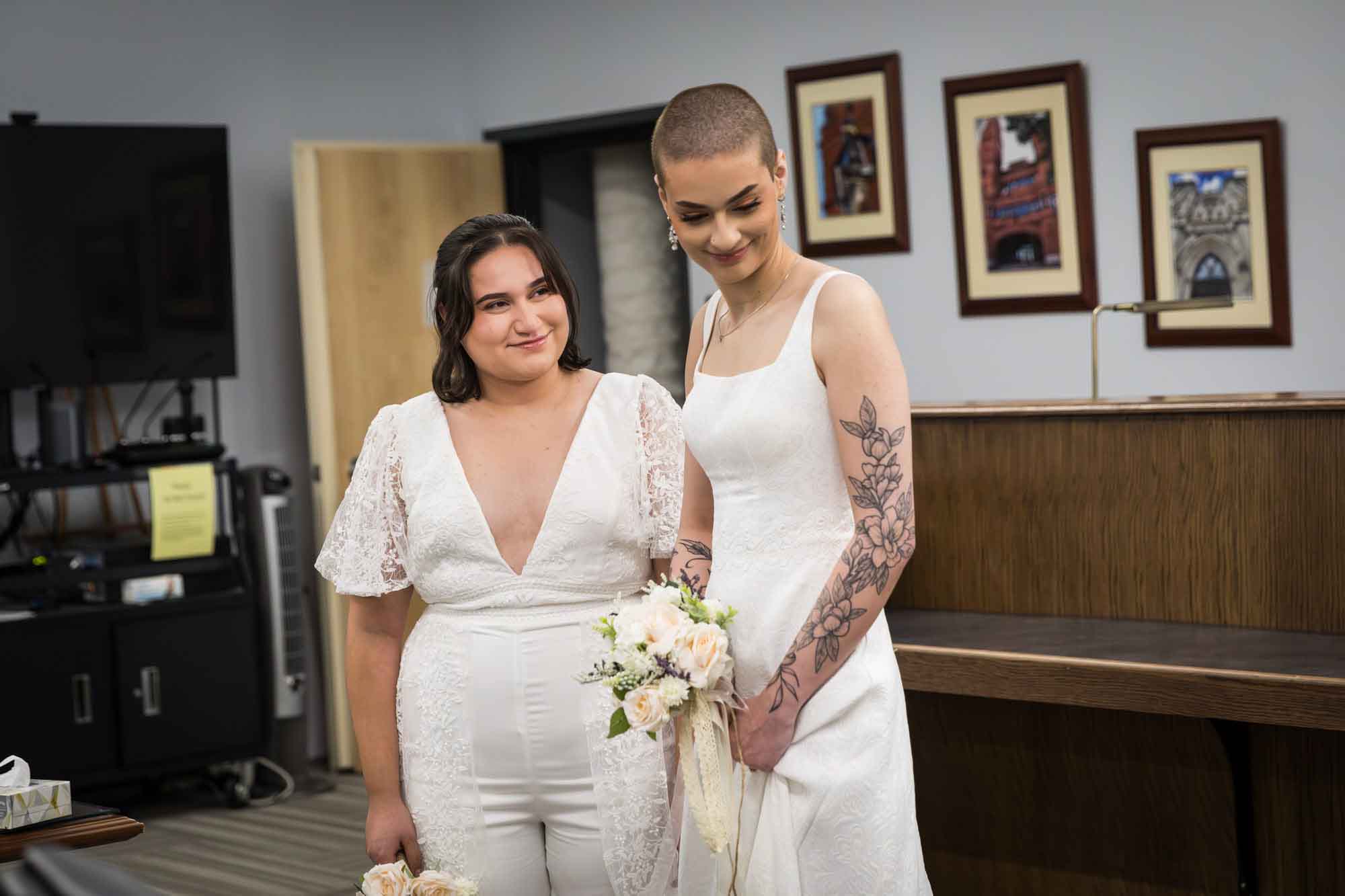 Two brides dressed in white during wedding ceremony at Bexar County Courthouse Precinct 3