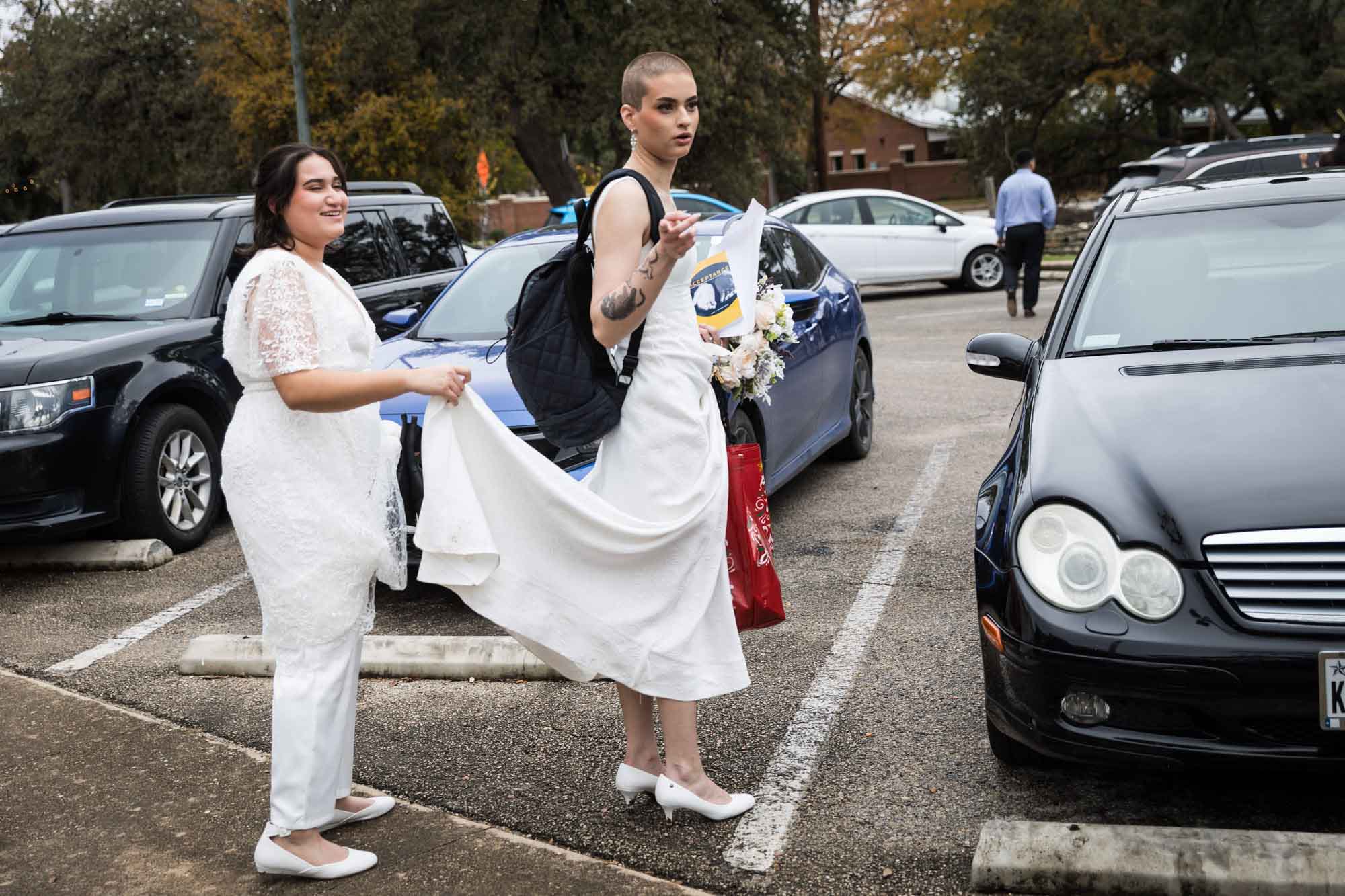 Walker Ranch Park wedding photos of two brides dressed in white holding skirts in parking lot