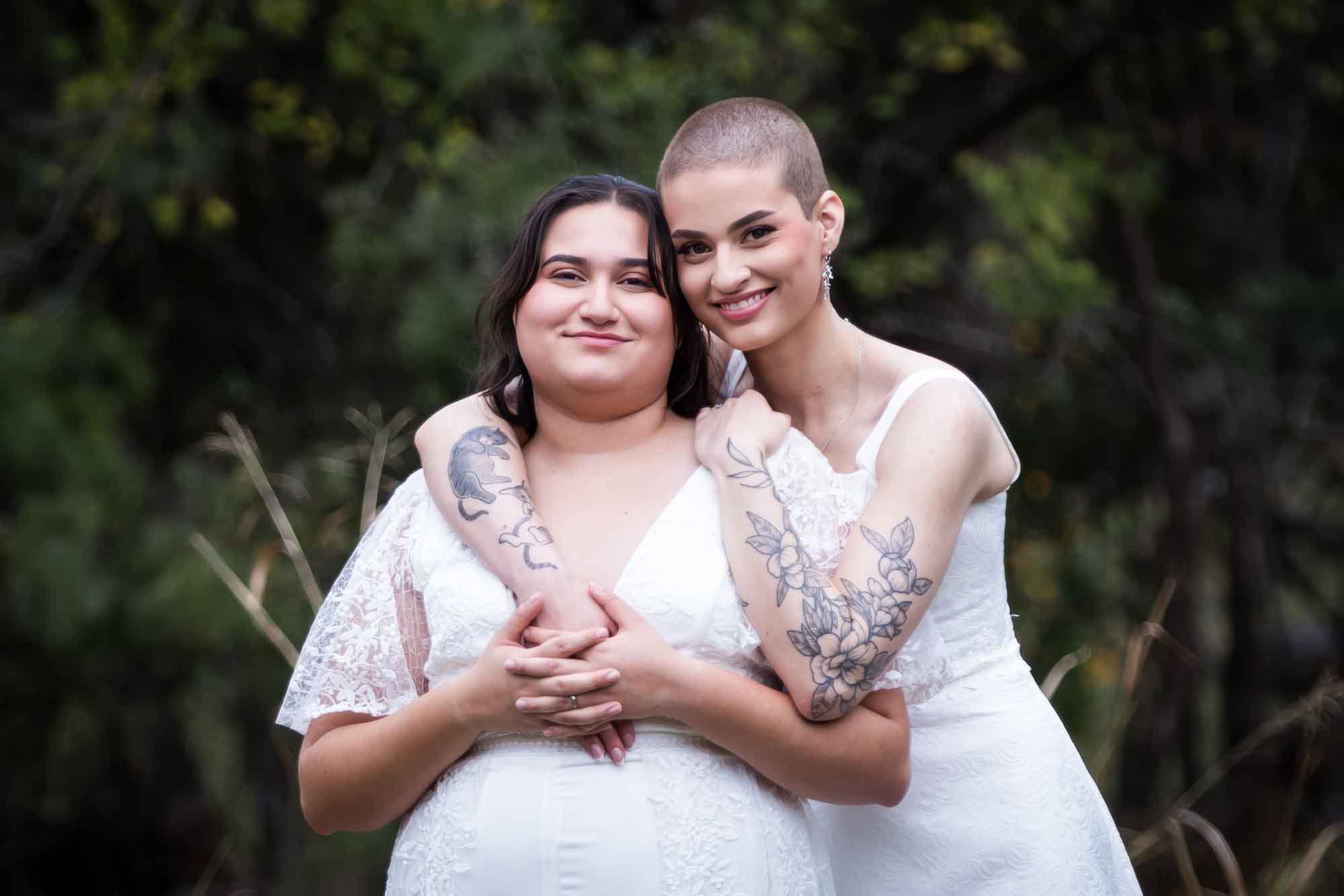 Walker Ranch Park wedding photos of two brides dressed in white hugging with arms around one another