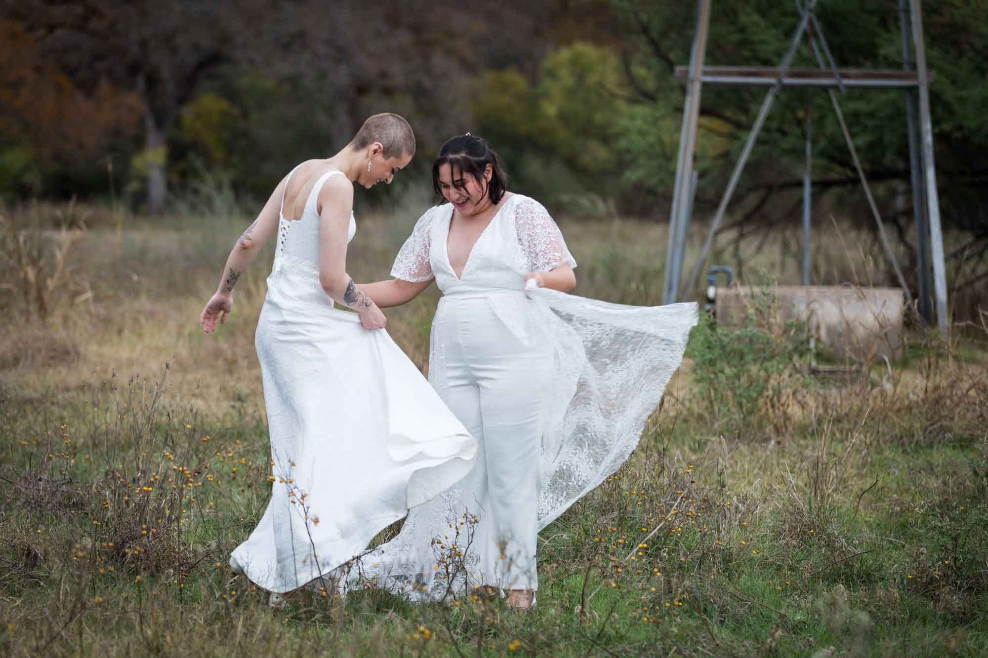 Walker Ranch Park wedding photos of two brides dressed in white dancing in the grass