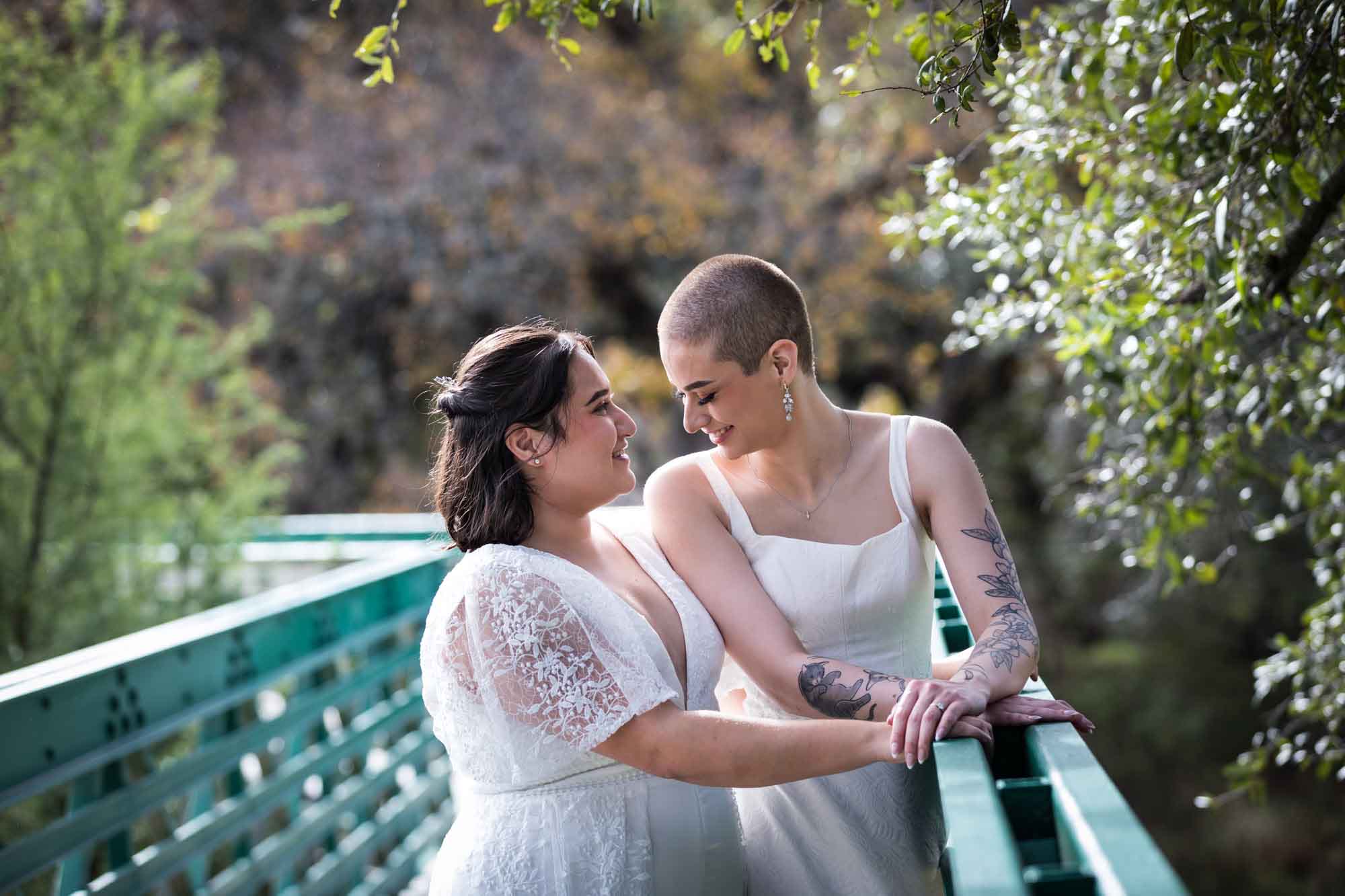 Walker Ranch Park wedding photos of two brides dressed in white standing on green bridge