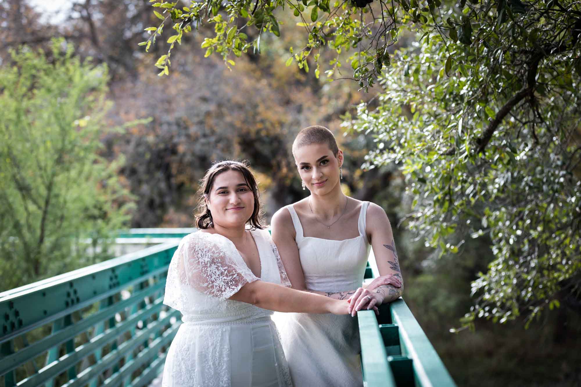 Walker Ranch Park wedding photos of two brides dressed in white standing on green bridge