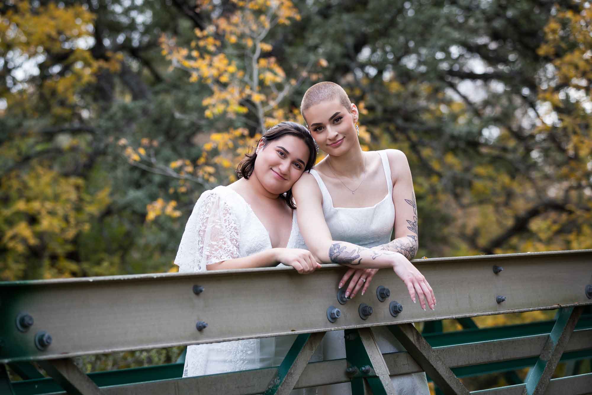 Walker Ranch Park wedding photos of two brides dressed in white leaning on bridge railing