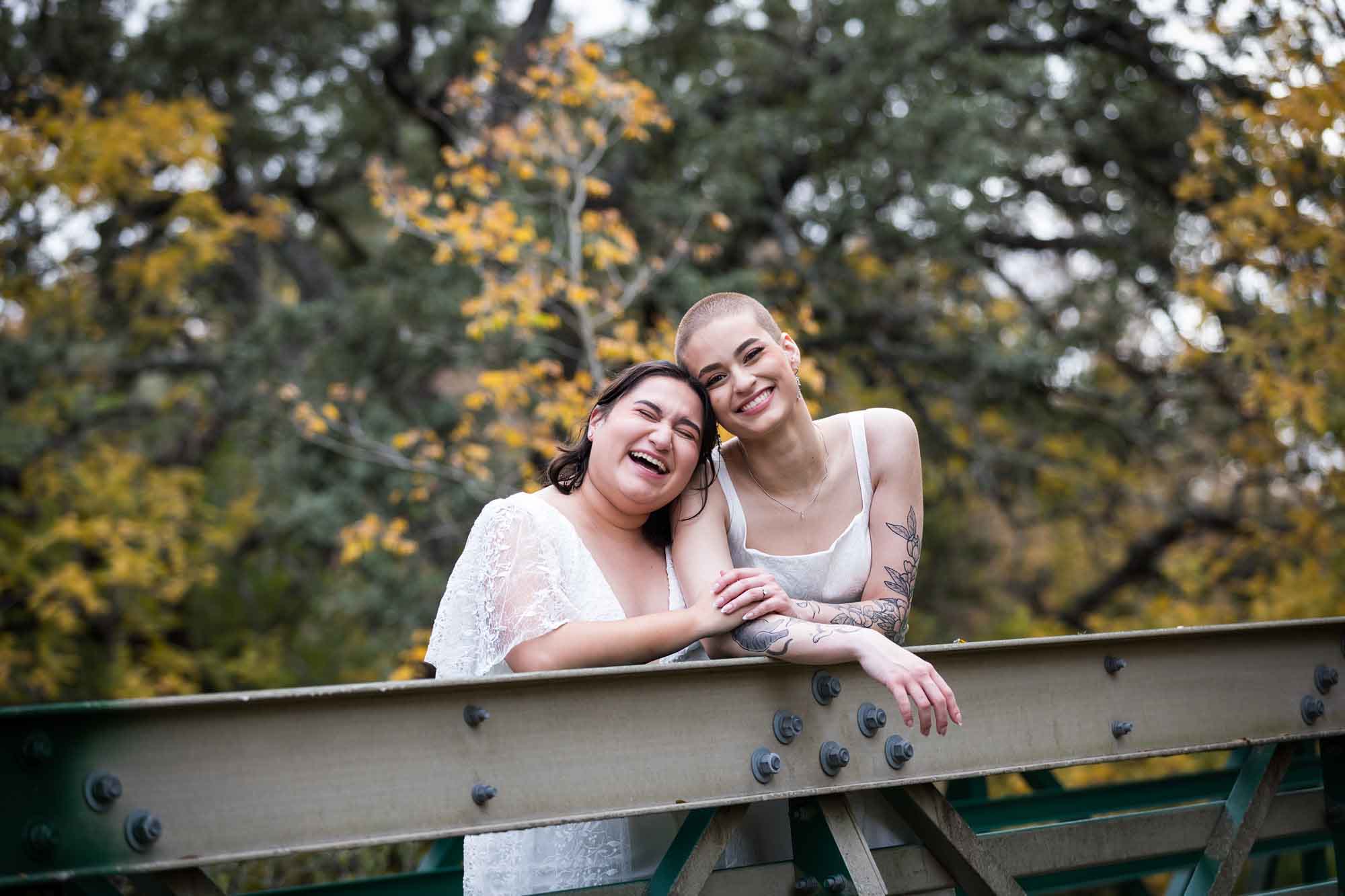 Walker Ranch Park wedding photos of two brides dressed in white leaning on bridge railing