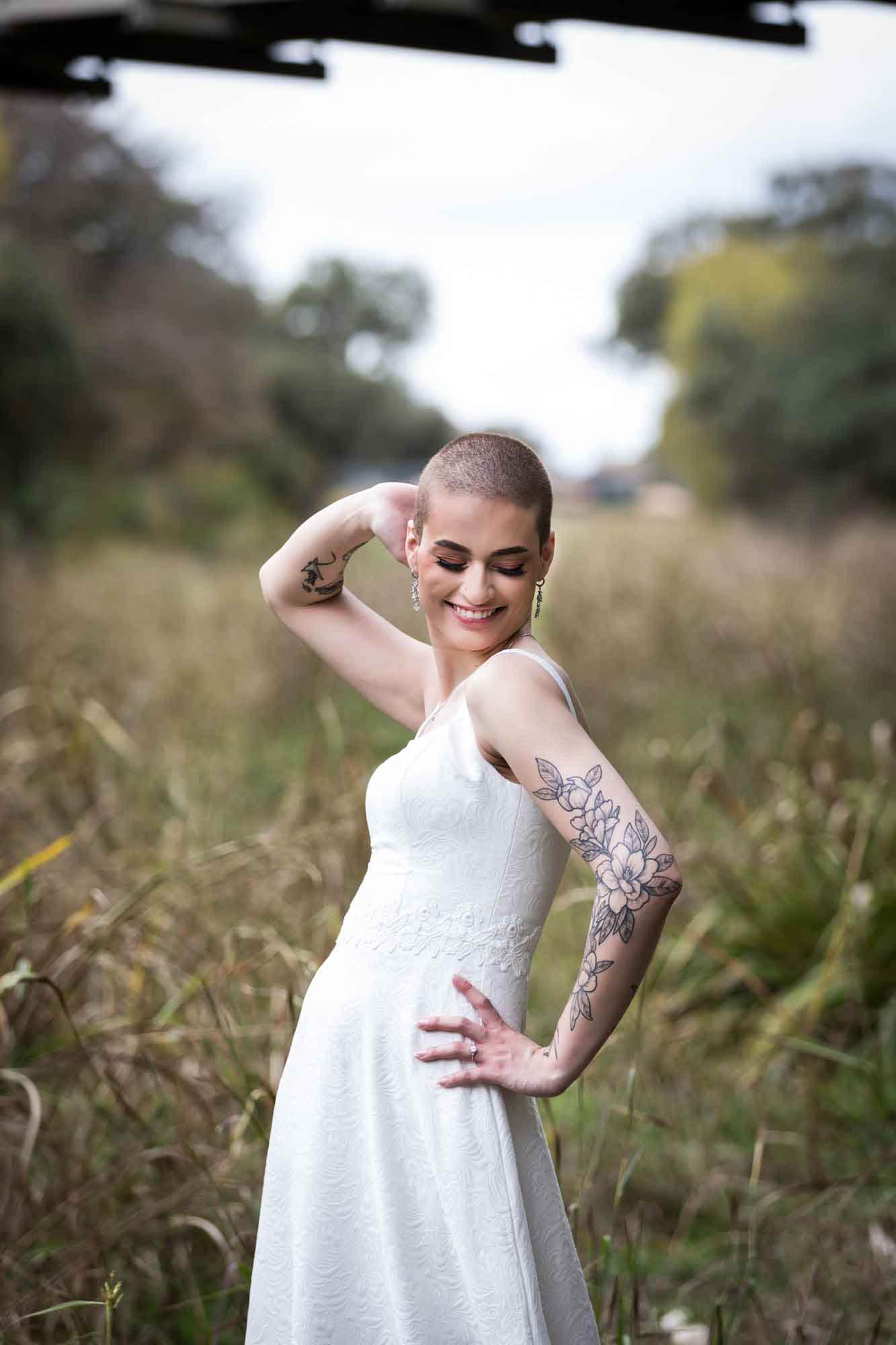 Walker Ranch Park wedding photo bride with shaved head posing in front of grass